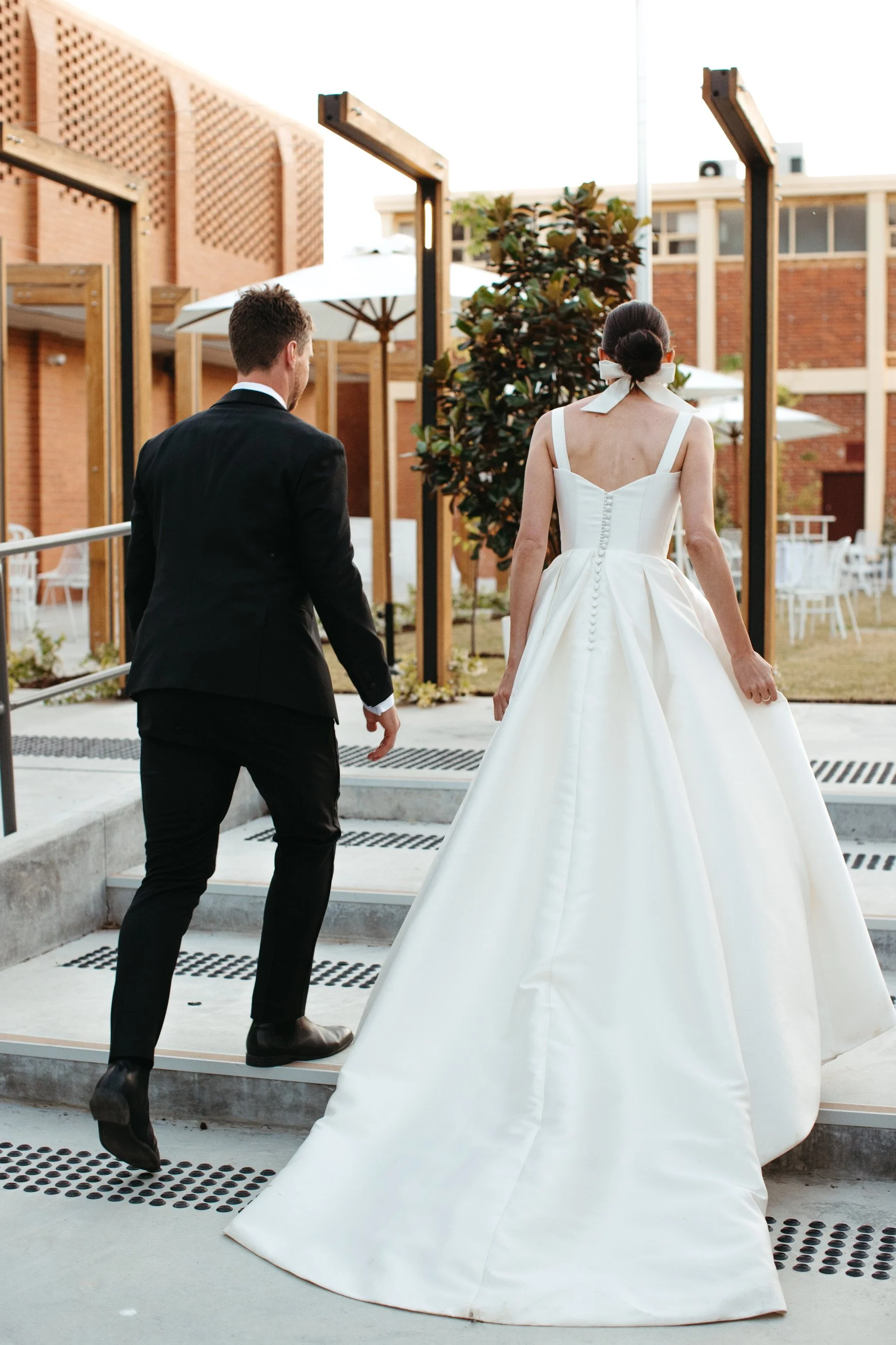 Lily and Jayden entering the Deniliquin Town Hall courtyard on their wedding day.