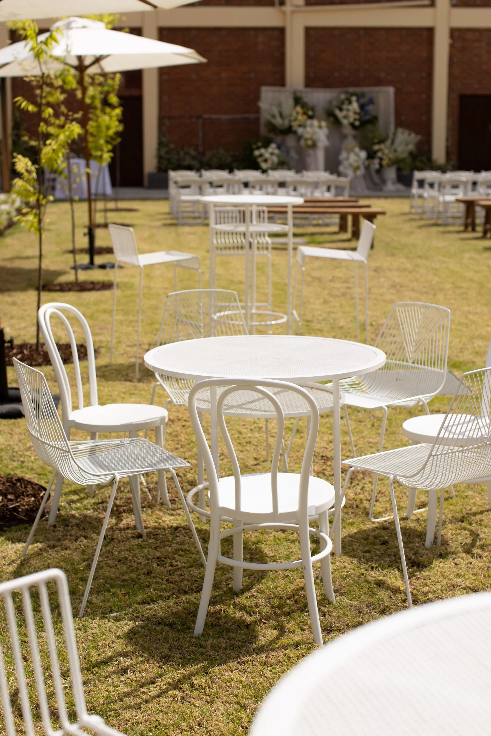 White café tables, bentwood chairs and wire chairs creating an outdoor wedding seating area in Deniliquin.