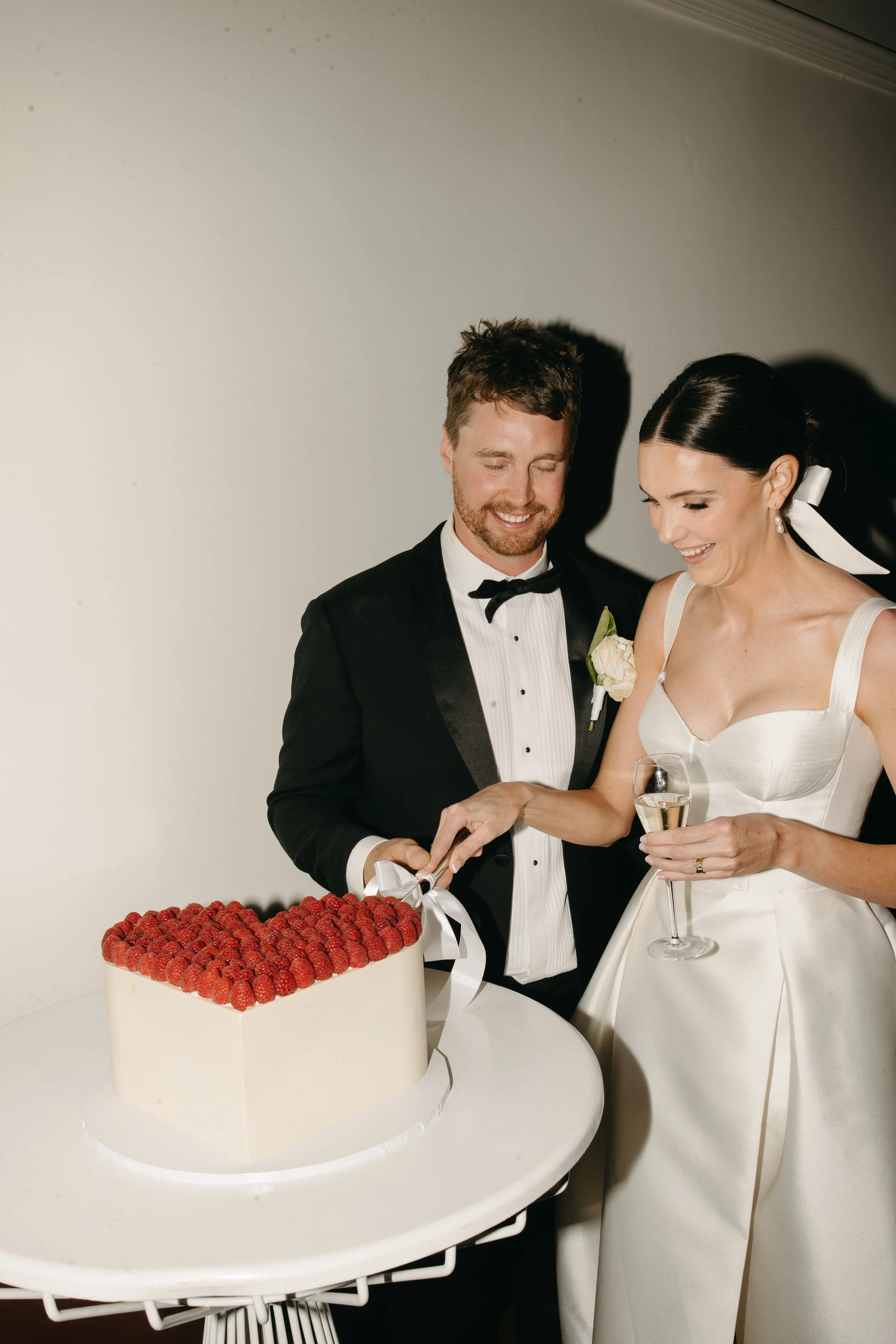 Lily and Jayden cutting their heart-shaped raspberry wedding cake during their Deniliquin wedding celebration.