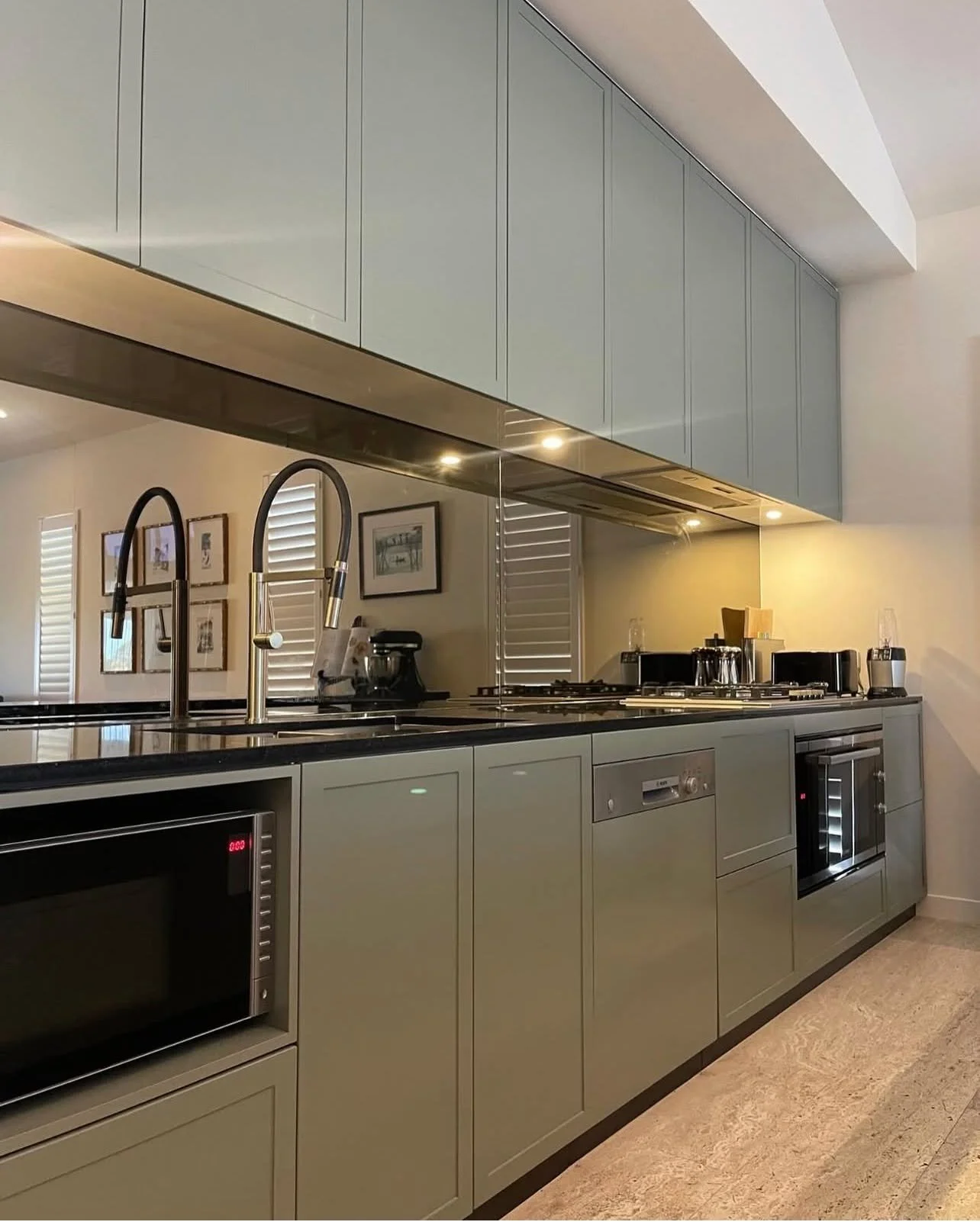 Smokey glass splashbacks were retained in this project, reflecting light from the floor-to-ceiling glass windows opposite.