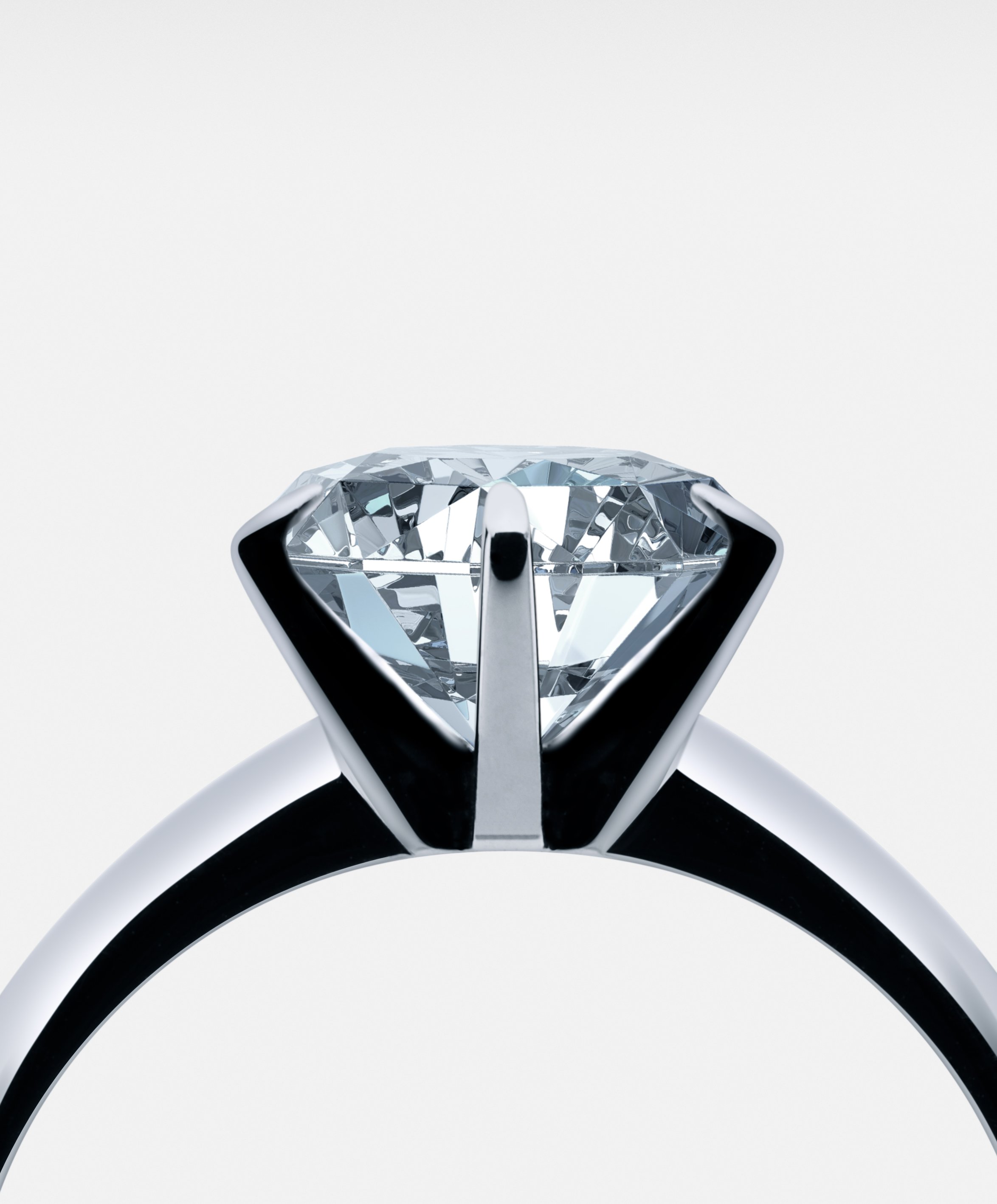 Close-up of a diamond ring with black and white band, viewed from above against a plain white background.