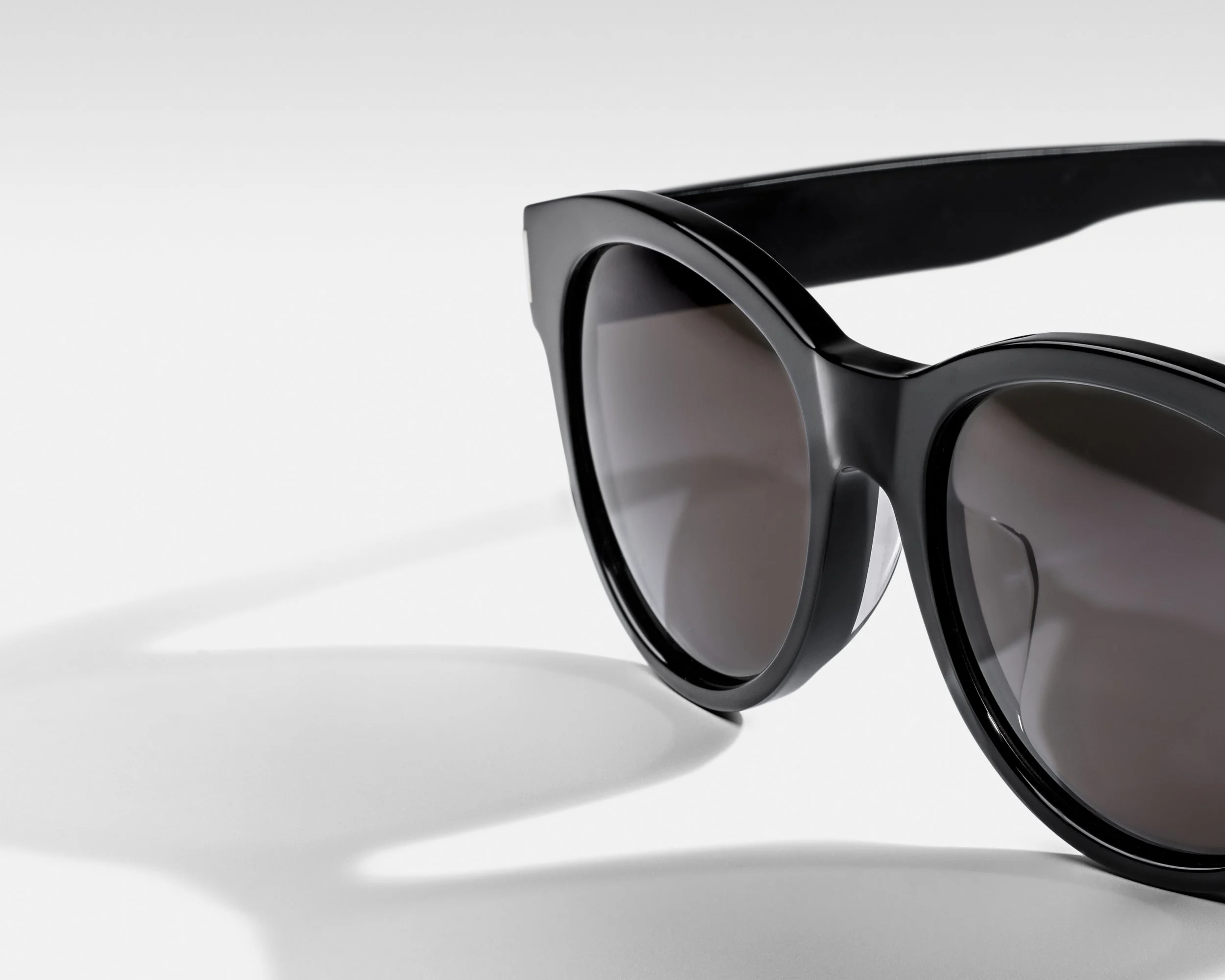 Close-up of a sleek, modern, black and silver virtual reality headset with shadow on a white background.