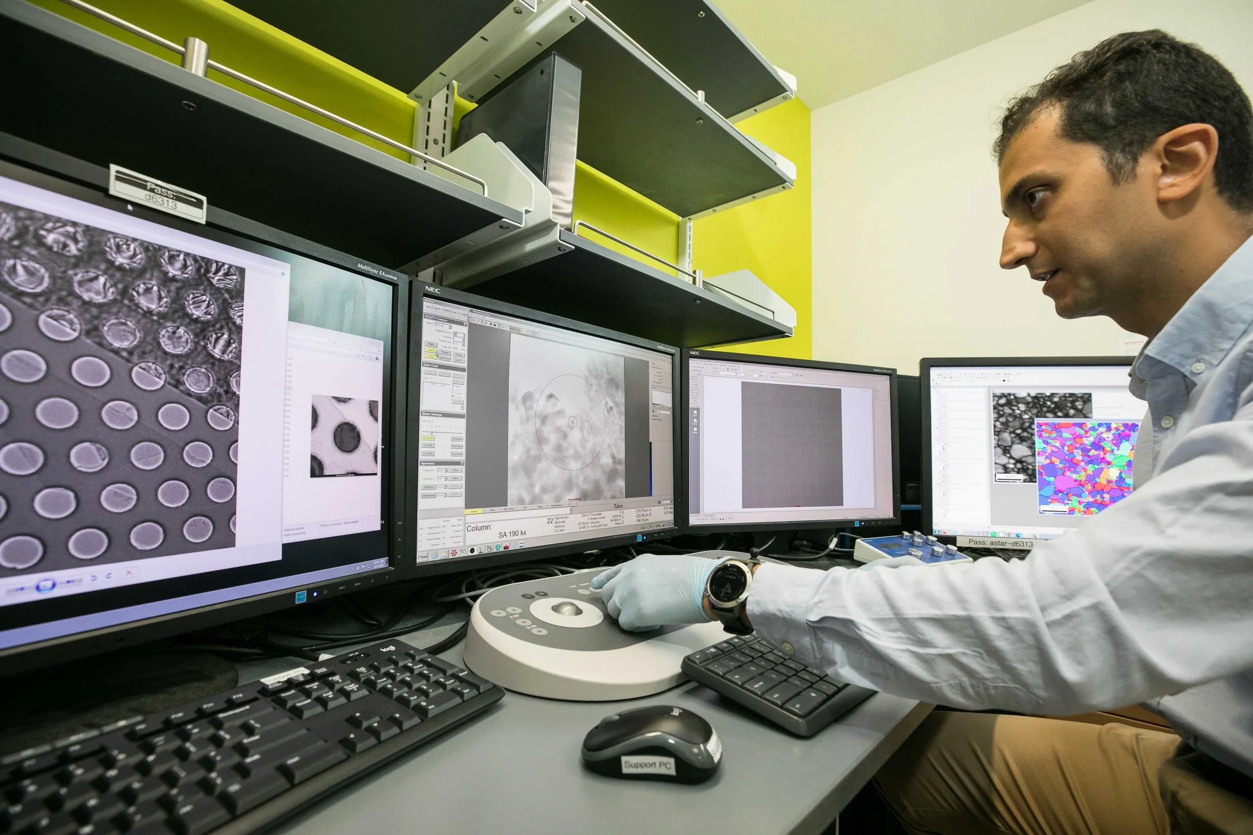 User adjusting control interface of the Transmission Electron Microscope (TEM) in the Electron Microscopy Lab to capture high-resolution images of a nanoscale sample