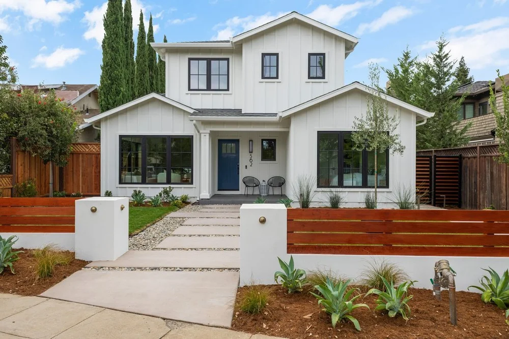 562 Palm Avenue in Los Altos, with white vertical siding, gabled roofs, dark window frames and a covered front entry