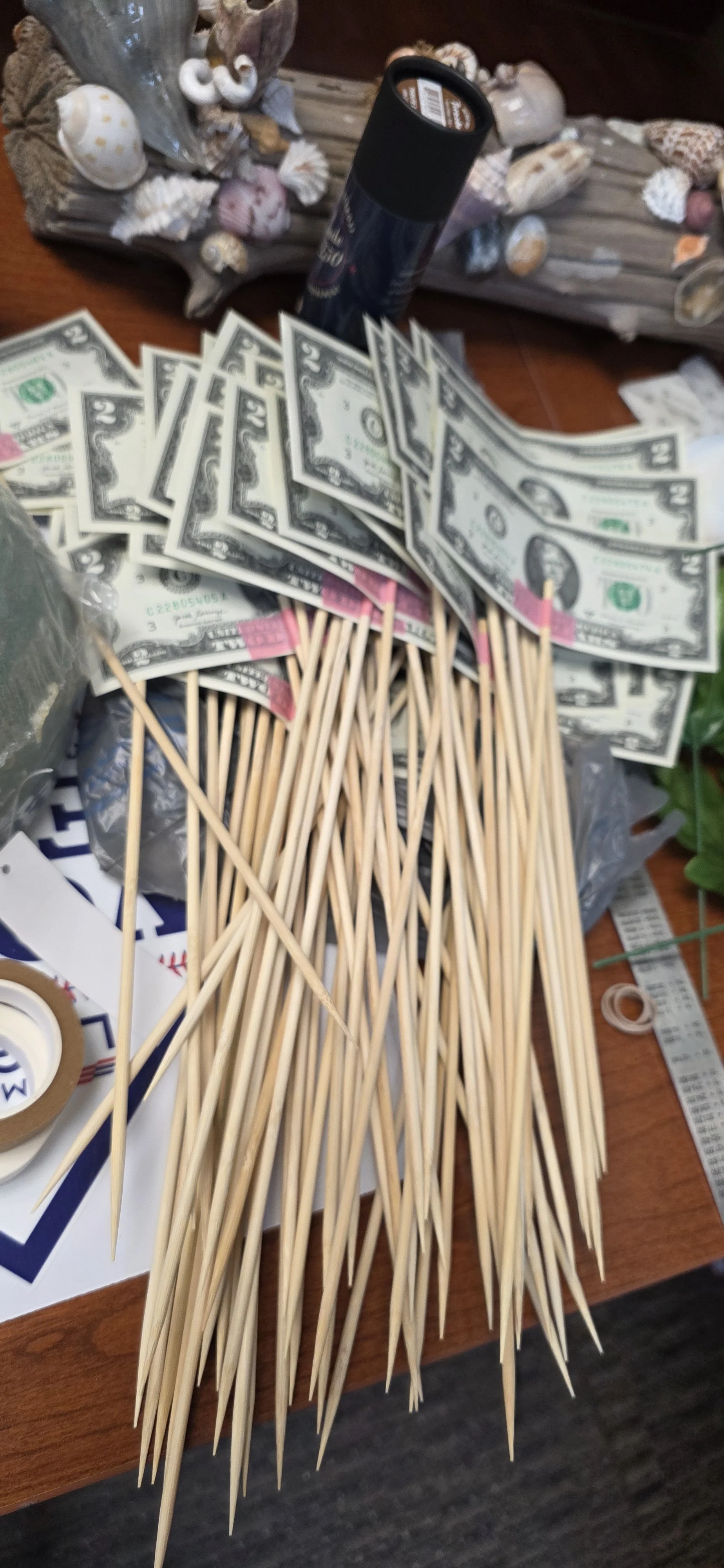 Paper taping the bills to the skewers