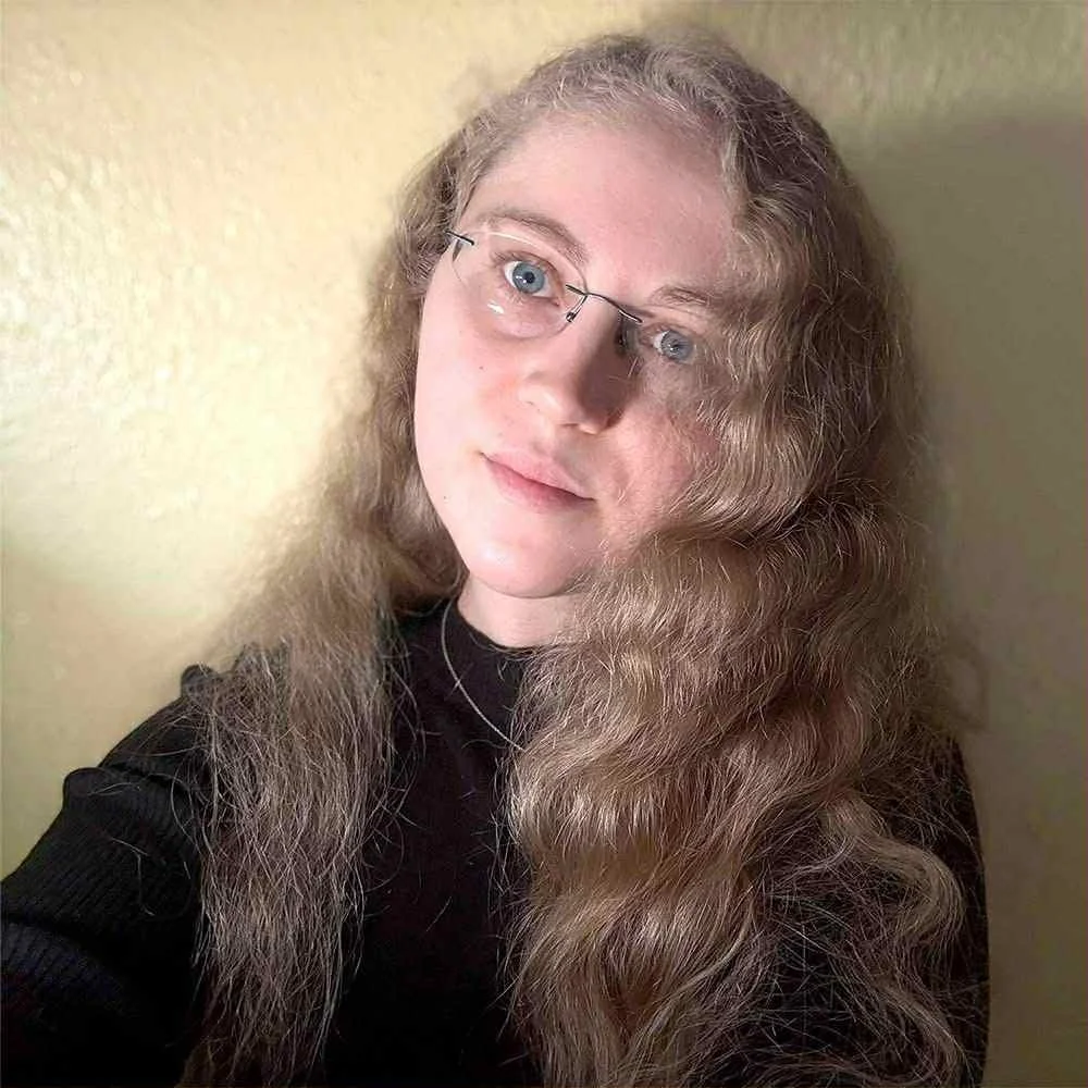Charlotte Beadle photographer portrait with long wavy hair and glasses