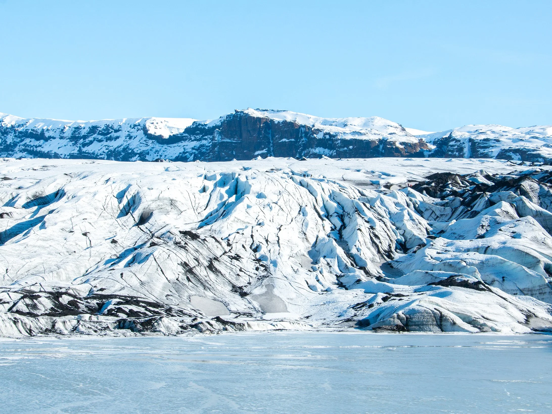 Glacial ice formations with crevasses and snow-capped mountains Iceland
