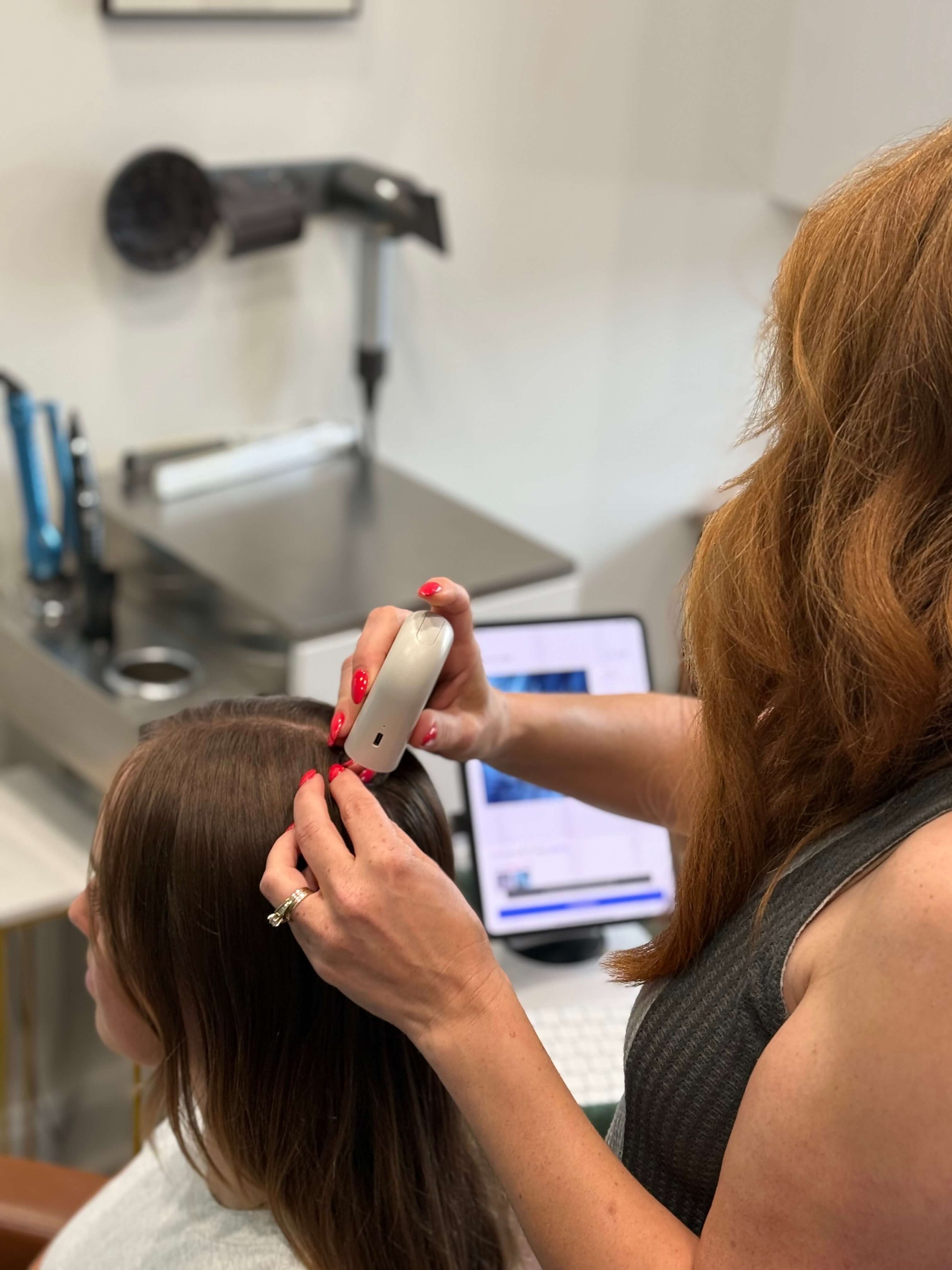 Suzi using the Becon Professional Scalp Device Pro to perform a hair and scalp analysis for thinning hair at Root Revival Hair Restoration in Forsyth County Cumming GA, where all services are performed by a Board Certified Trichologist.