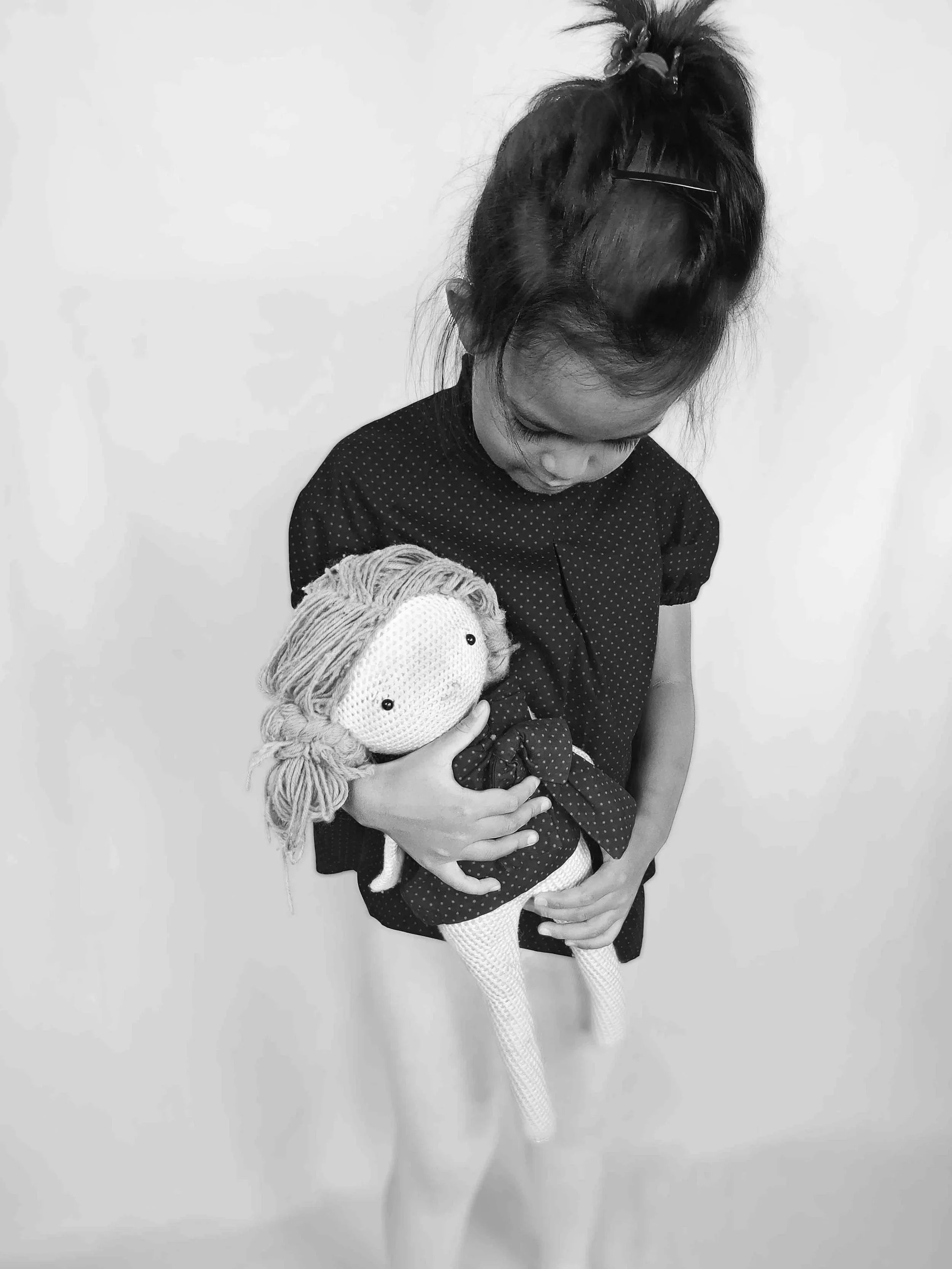 Une petite fille qui porte la blouse à pois - MIA ,de la marque Lov'Heli. La photo est en noir et blanc.