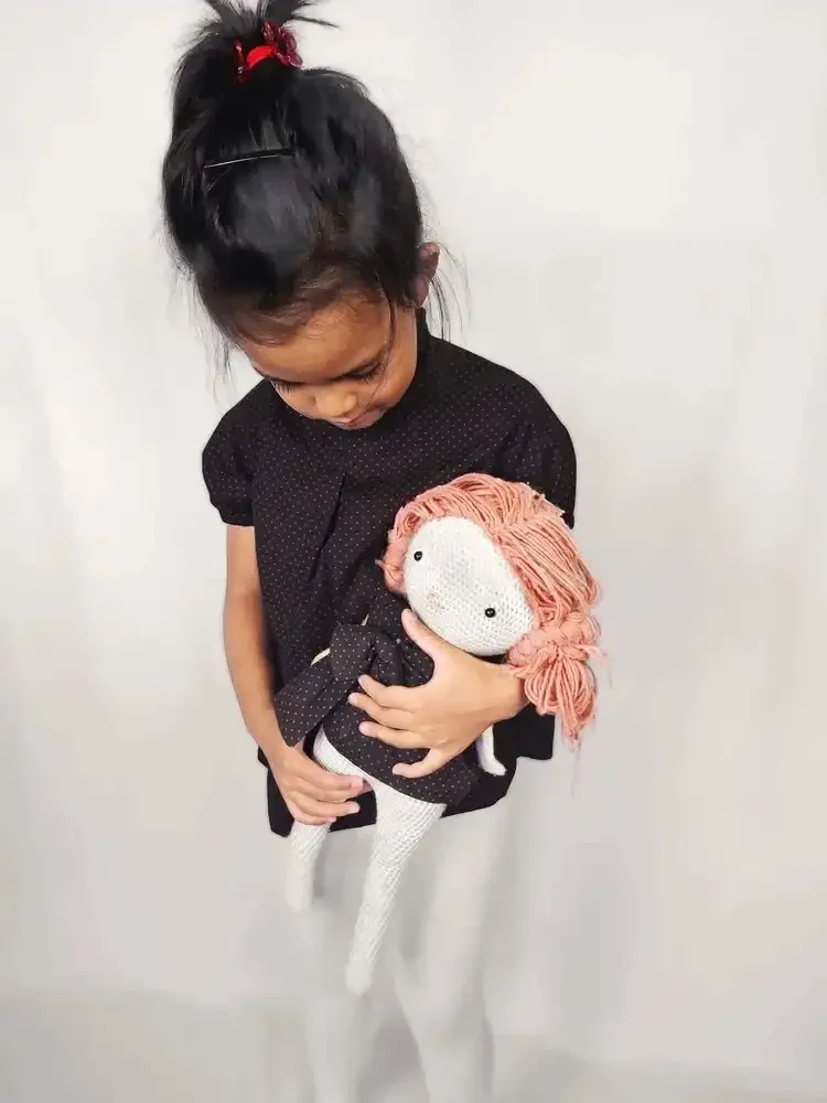 Une petite fille qui porte la blouse à pois, de couleur marron, MIA de la marque Lov'Heli