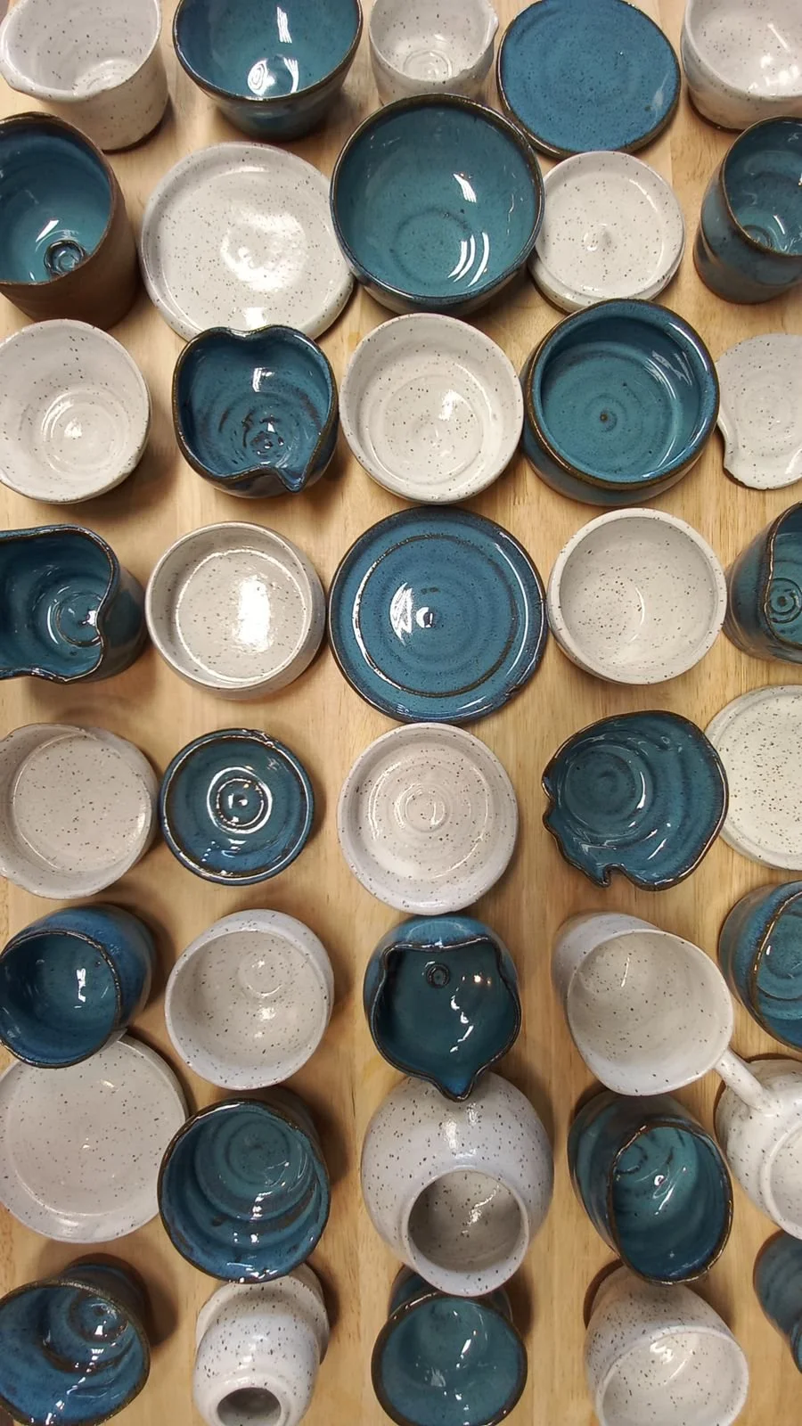 Blue and white pottery pieces made by students in intro to the wheel class.
