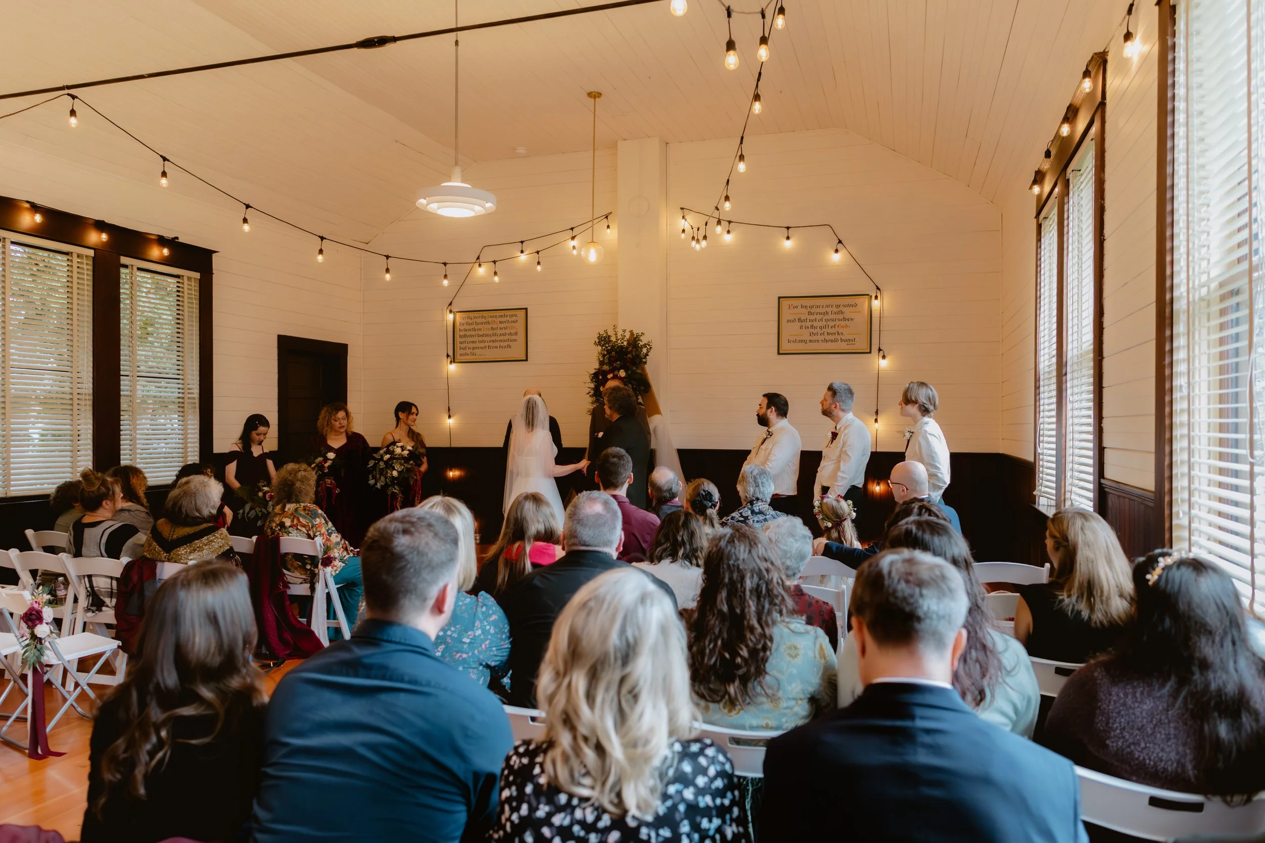 Wedding guests gathered for an indoor ceremony at Hummingbird Hall