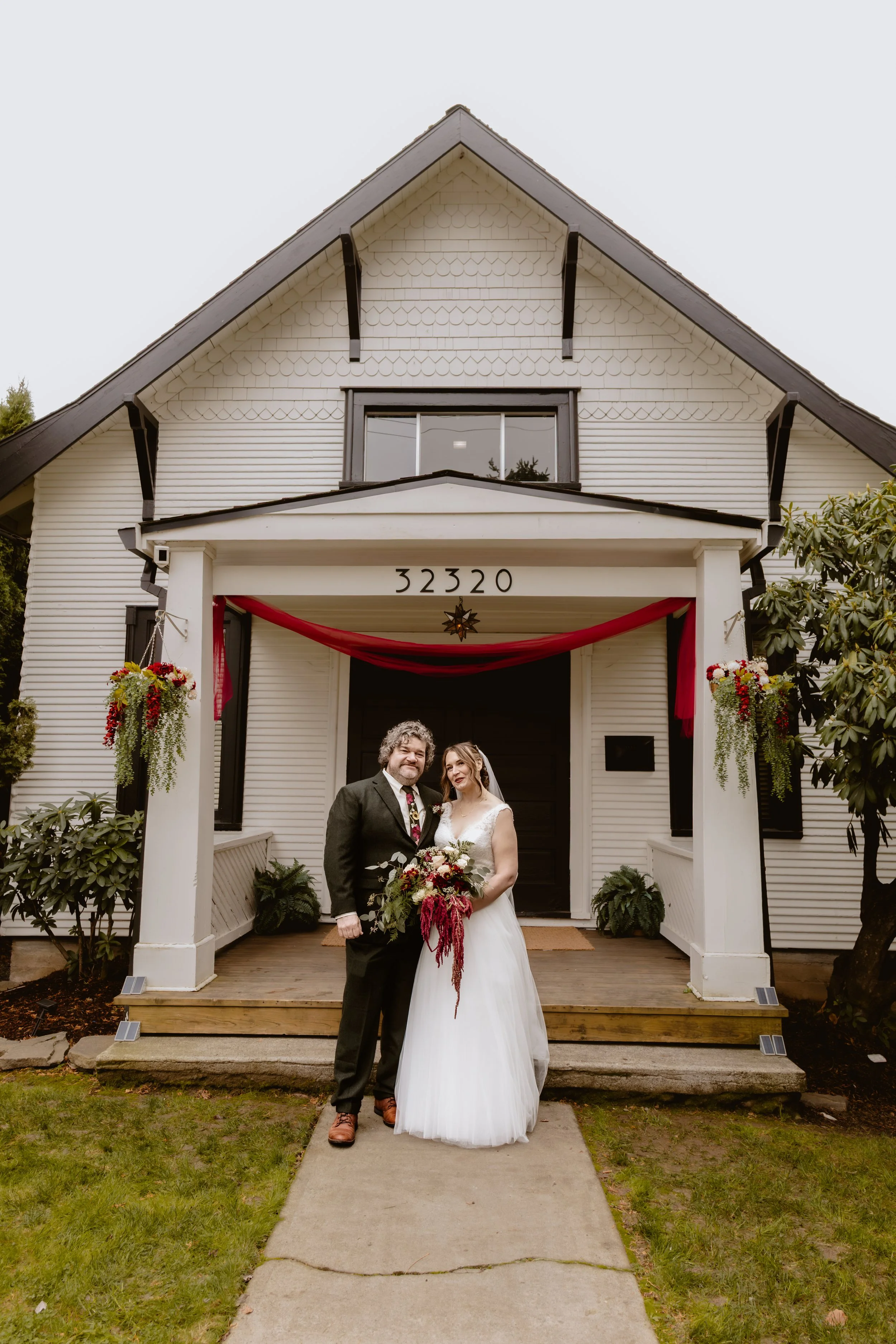 Bride and groom beneath the historic entrance of Hummingbird Hall in Corbett, Oregon
