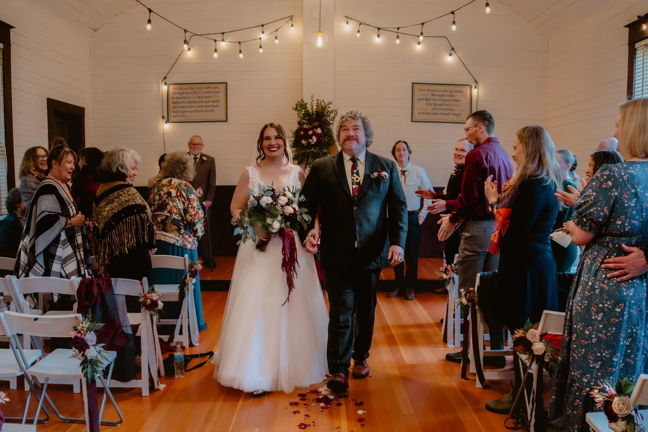 Newlyweds walking down the aisle after their indoor wedding ceremony