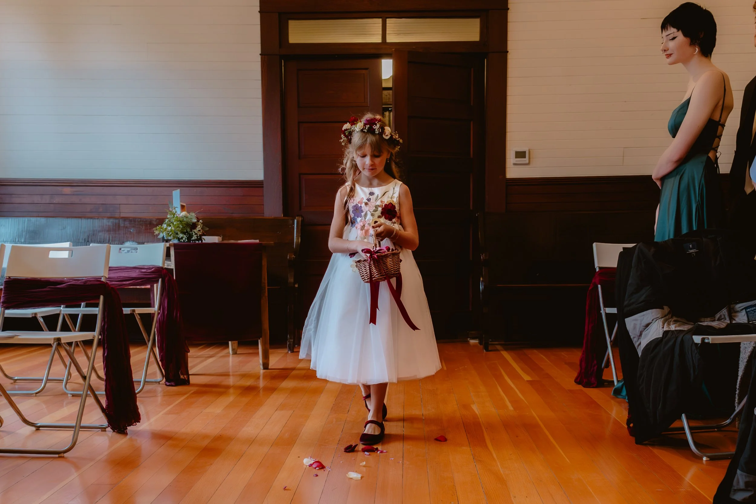 Flower girl walking down the aisle inside Hummingbird Hall's historic chapel