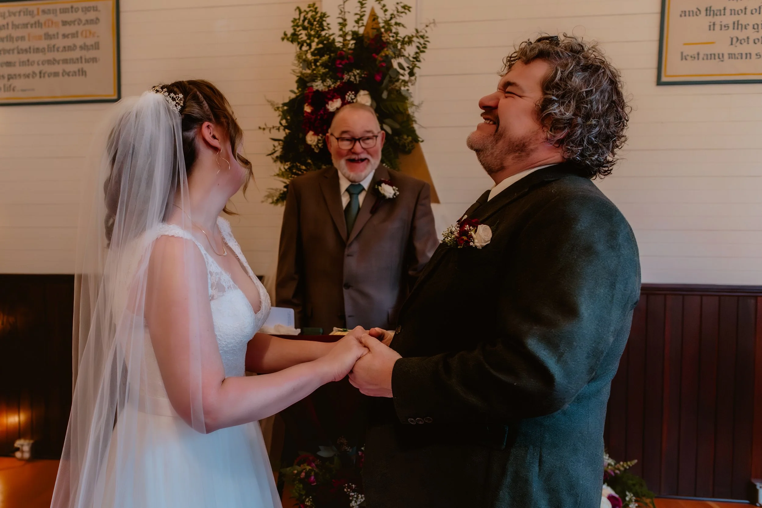 November wedding ceremony surrounded by warm wood floors and string lights at Hummingbird Hall