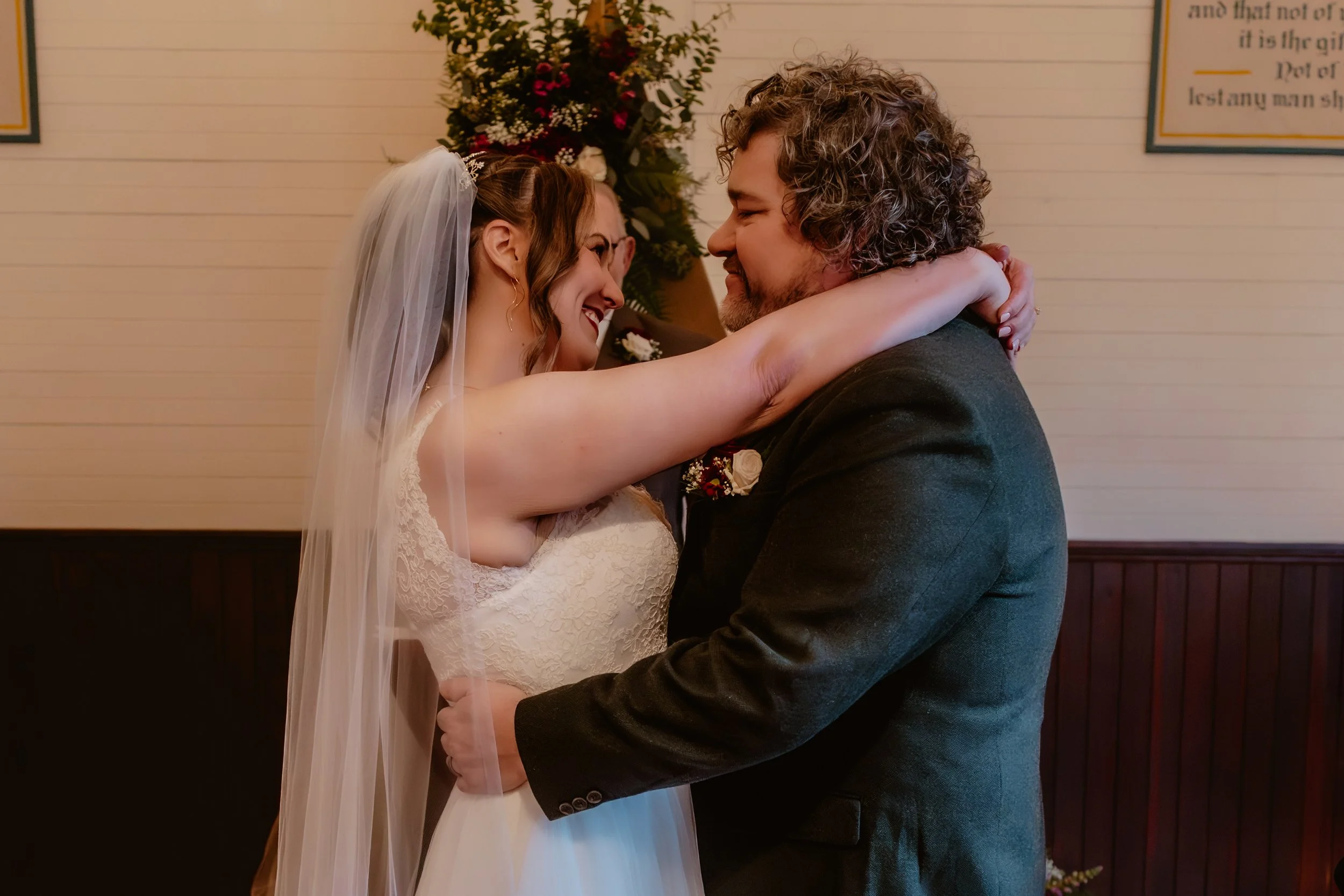 Bride and groom smiling during their wedding ceremony