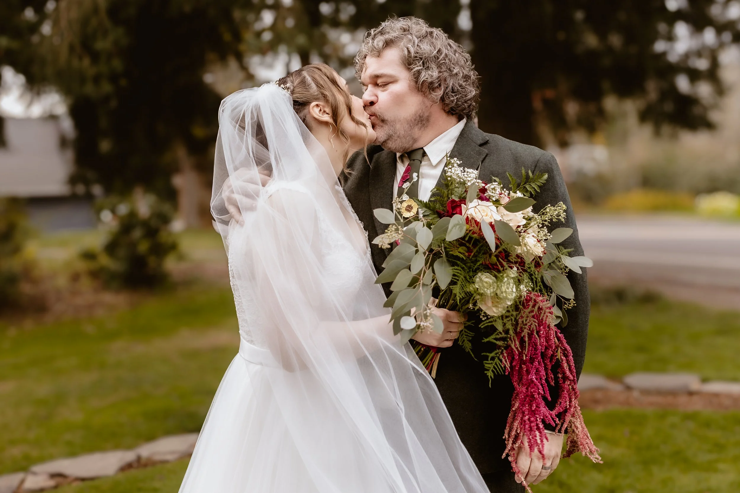 Bride and groom kissing outside Hummingbird Hall at their November wedding