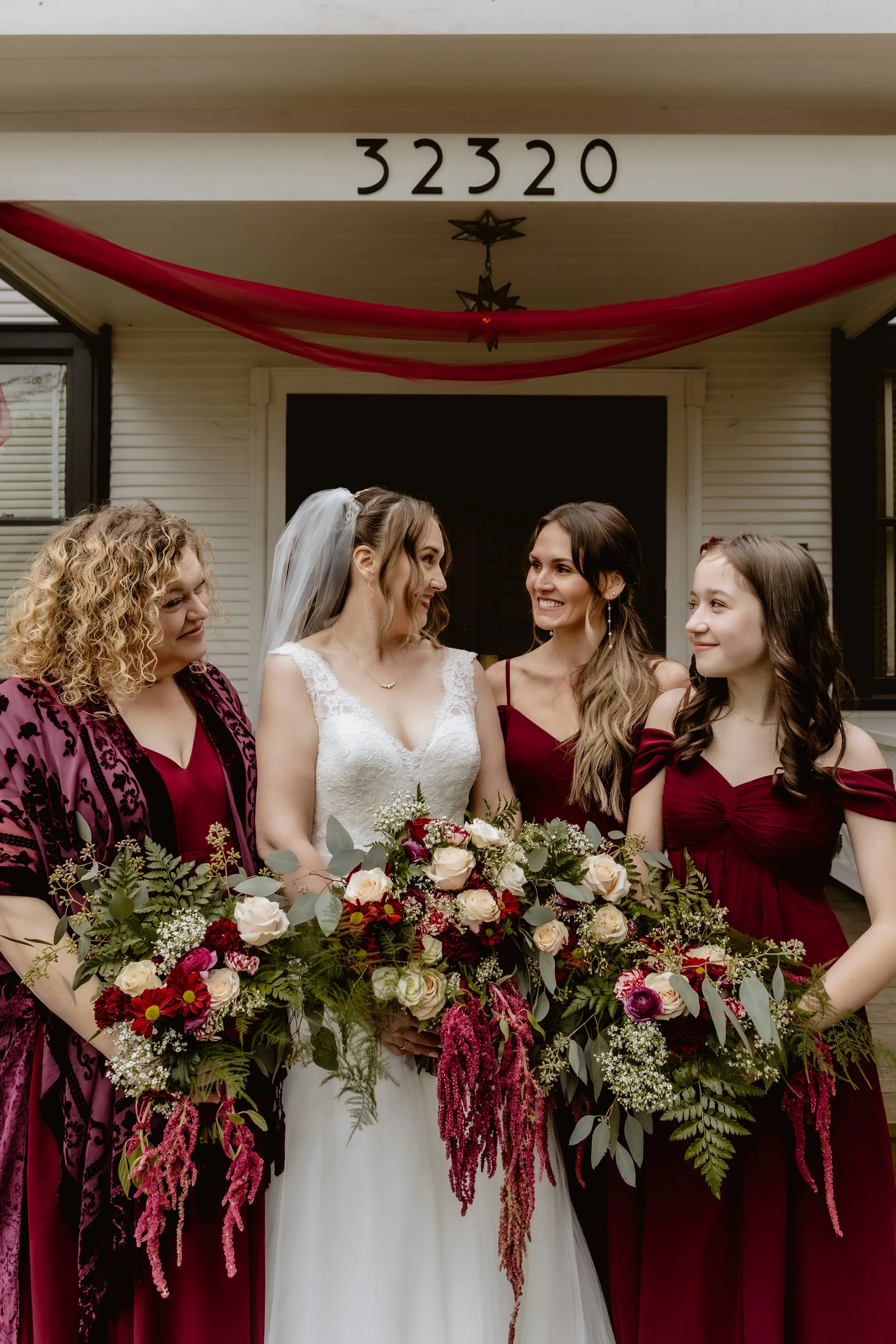 Bride and bridesmaids with burgundy and white fall wedding flowers