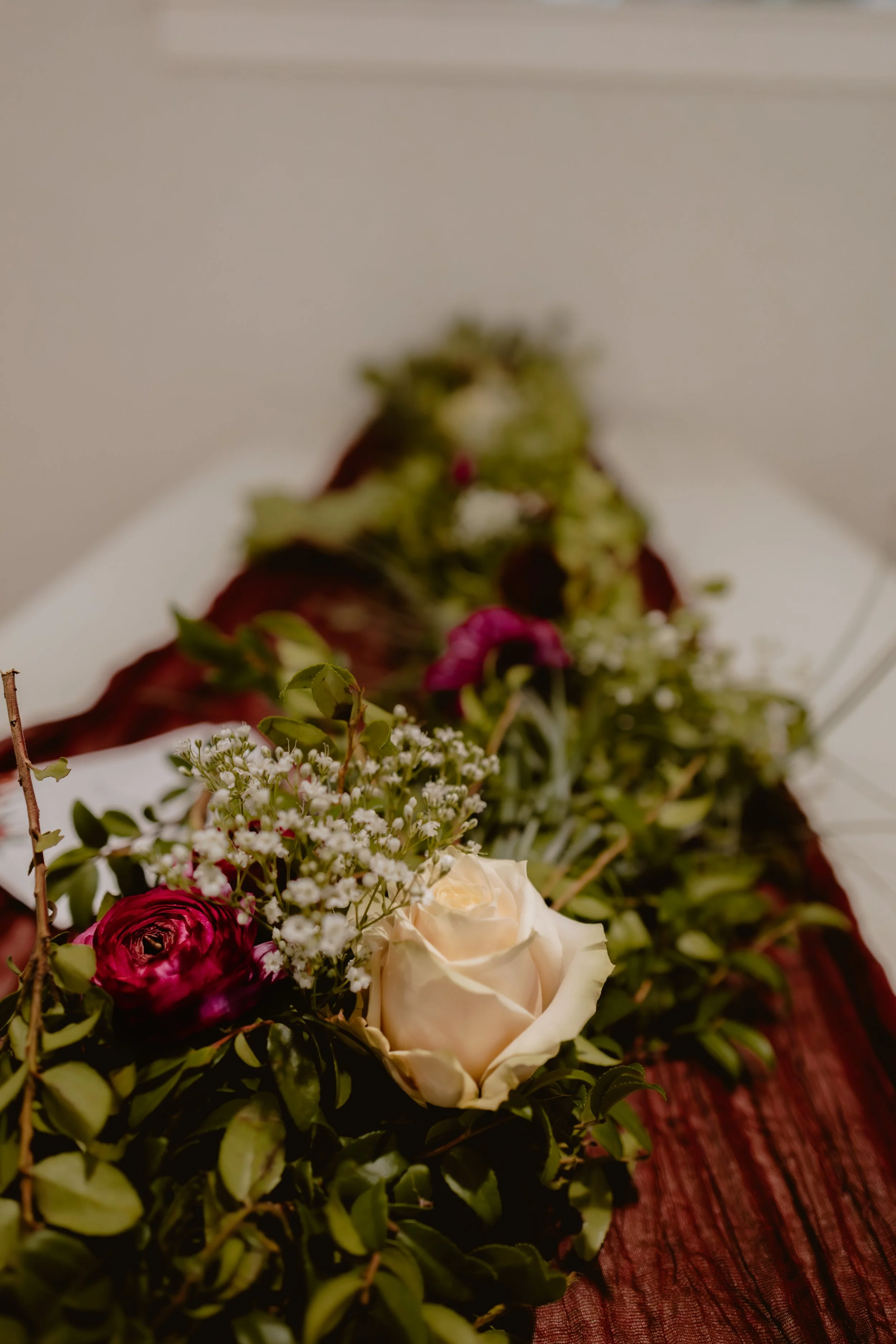Burgundy, cream and greenery floral details from a November wedding reception