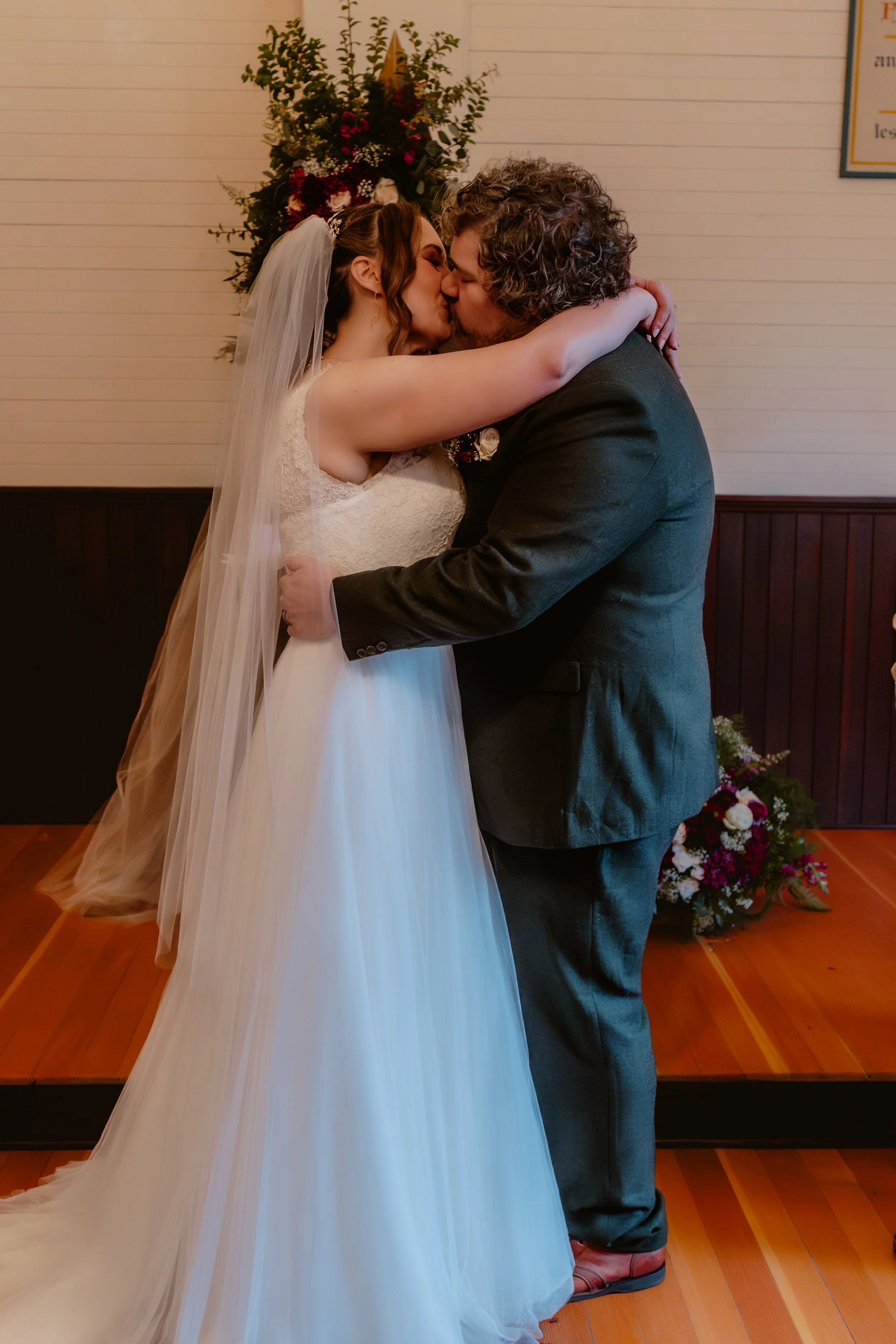 Bride and groom kissing during their wedding ceremony