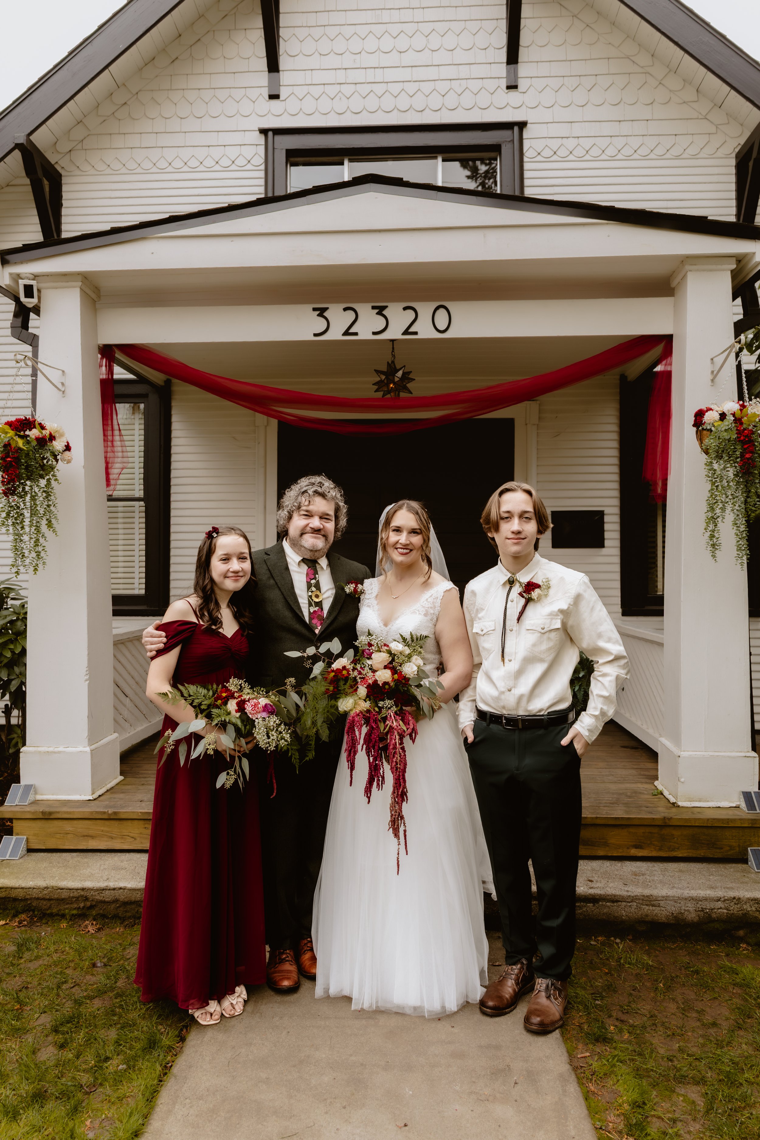 Wedding party gathered outside the entrance of Hummingbird Hall
