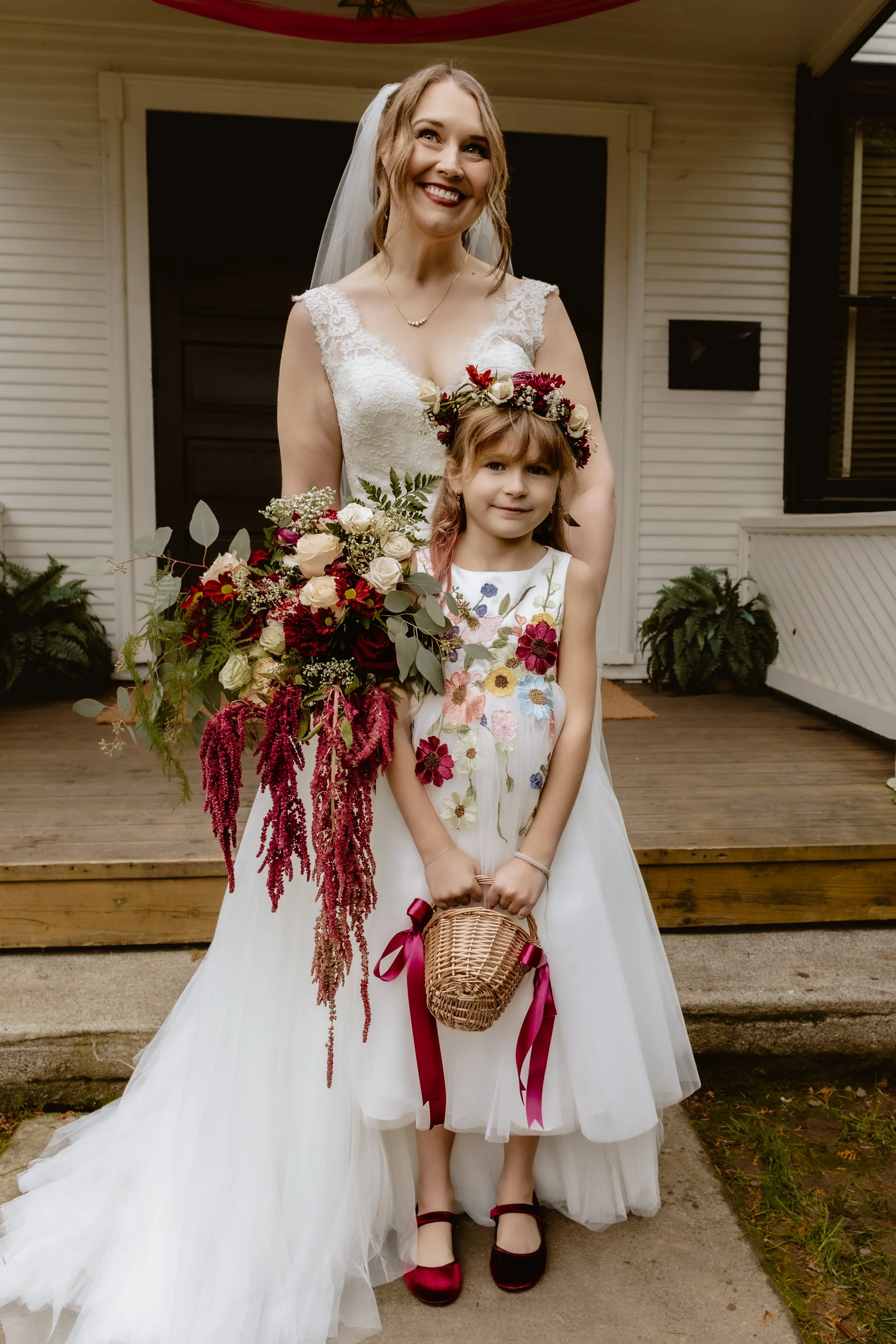 Flower girl holding a large fall wedding bouquet outside Hummingbird Hall