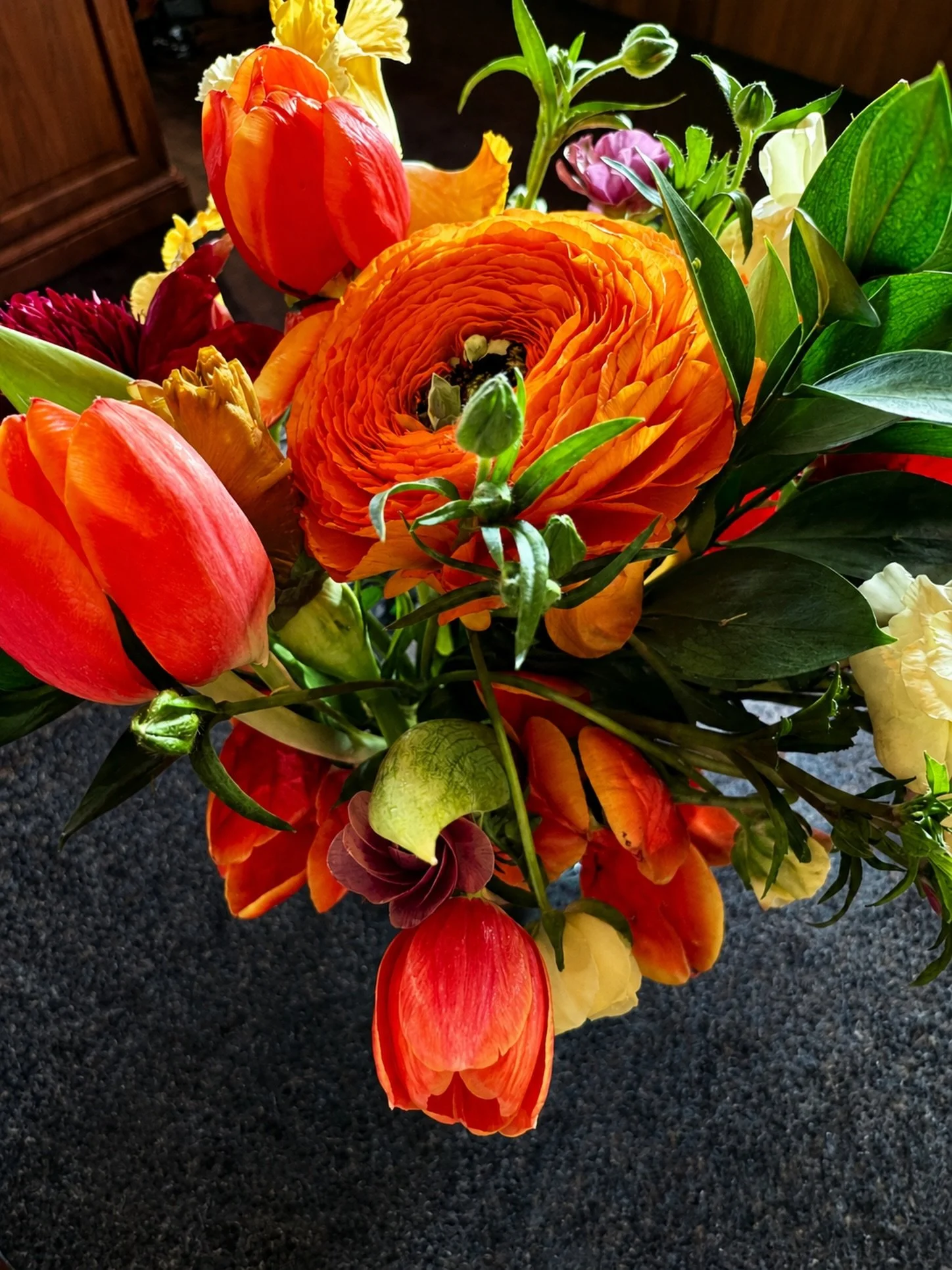 A detail from the Renaissance-inspired floral story.

Layered in luminous orange, crimson, ivory, and green, this arrangement was designed to feel painterly up close &mdash; a living still life with the drama, warmth, and movement of an old master pa