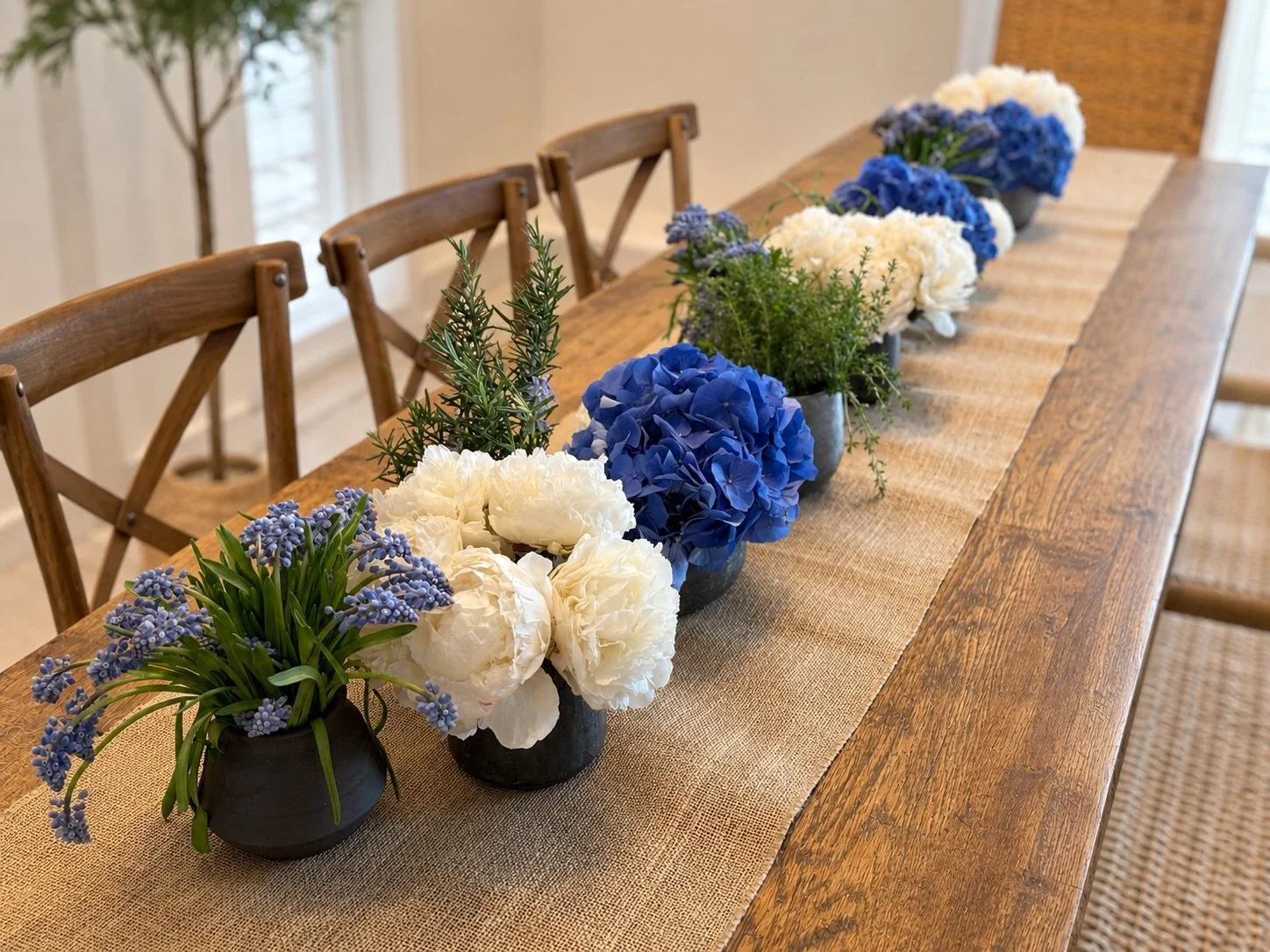 An understated tablescape, layered with texture, fresh florals, and effortless symmetry &mdash; designed by Cottone &amp; Co for intimate dinners that feel both elevated and inviting. The perfect balance of coastal blue, warm wood, and timeless enter