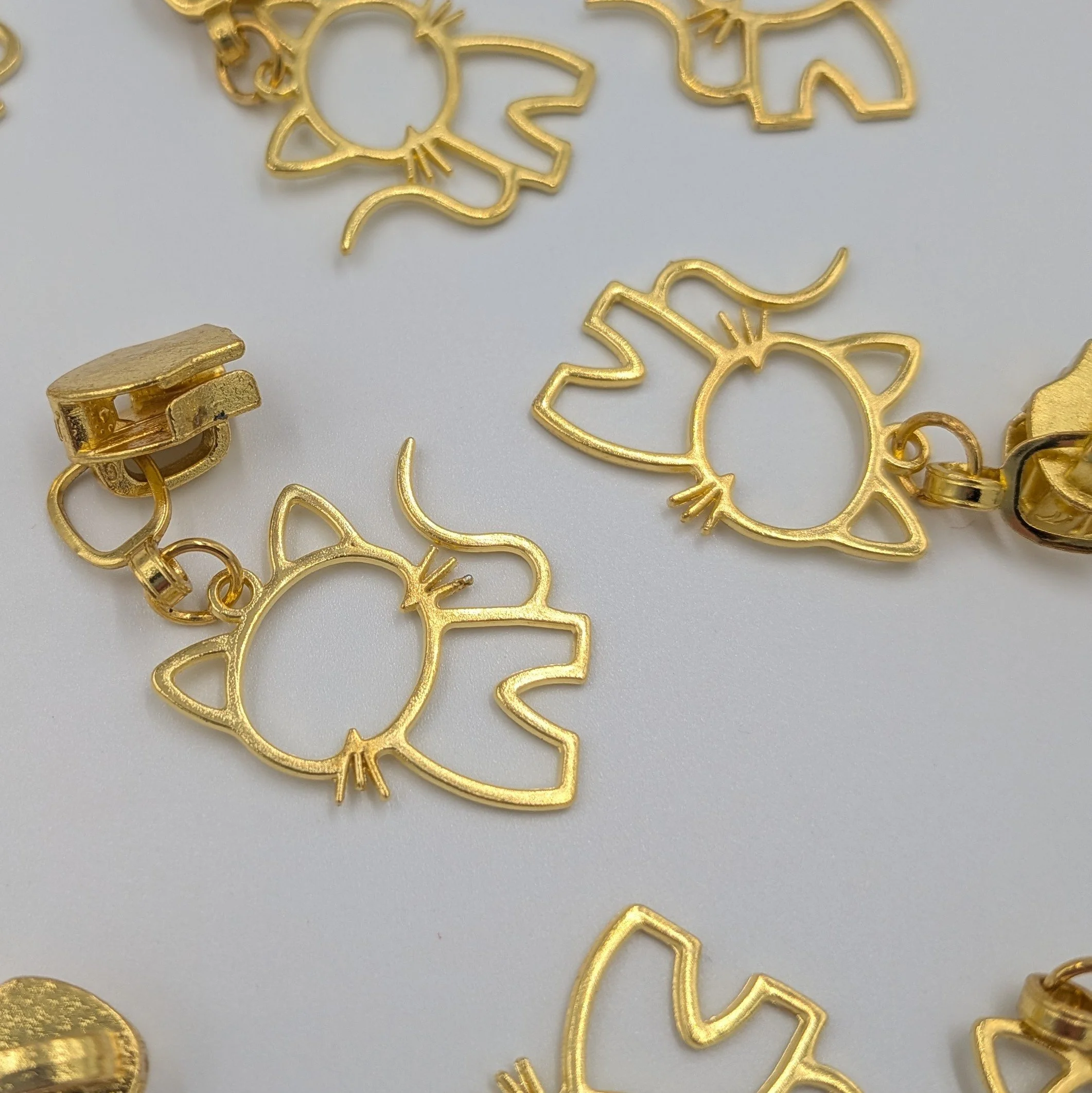 #5 gold coloured cat motif zip pull
