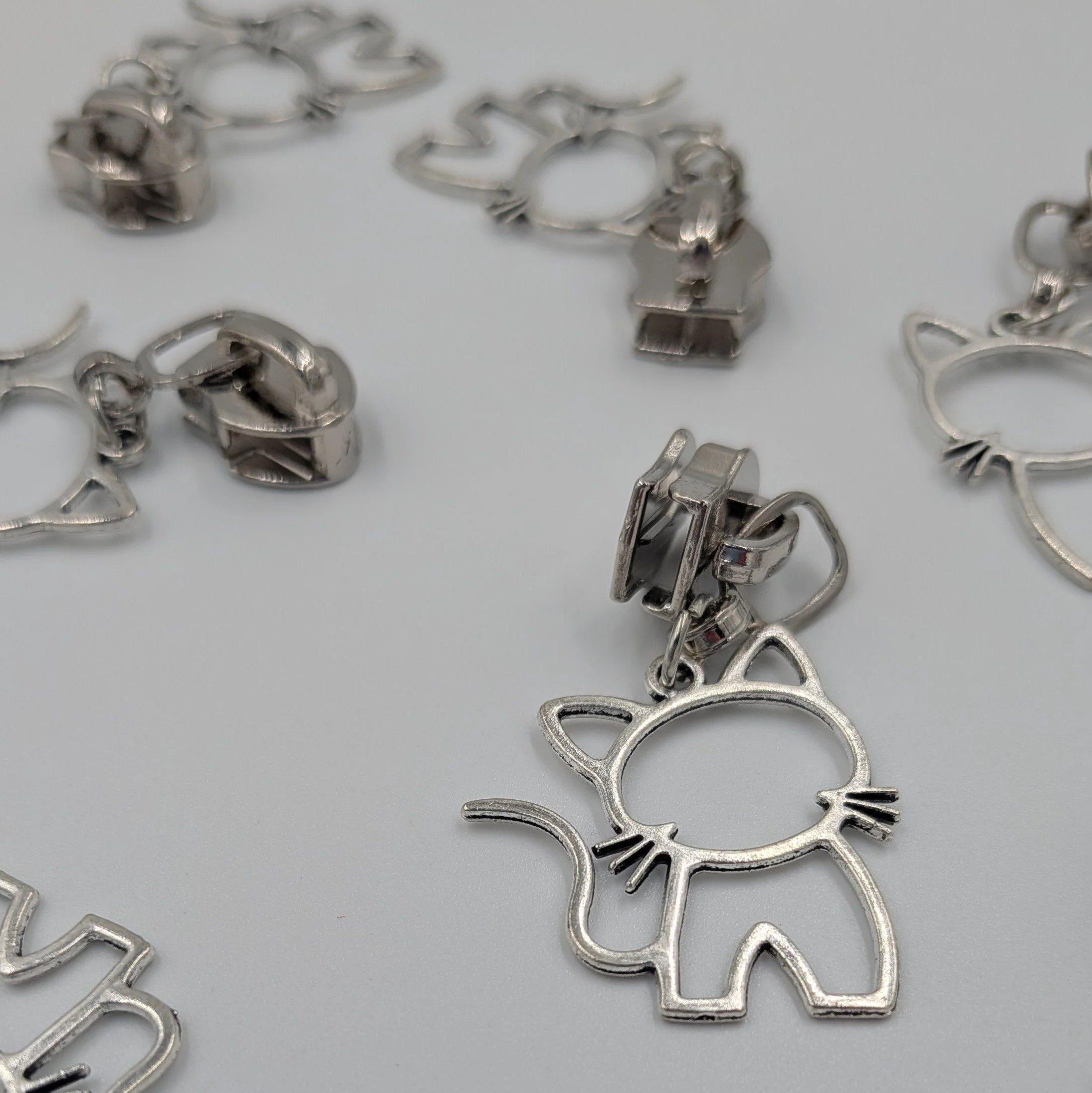 #5 silver coloured cat motif zip pull