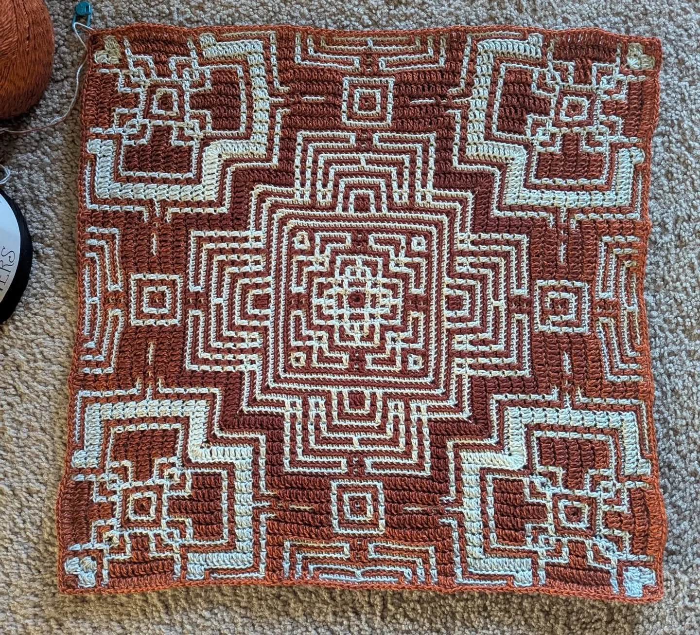 Here is progress of the new red and black project!
This is a mosaic design.  One cake of yarn is being worked from outside-in and the other inside-out. 

Now that I got a little experience from the green and white blocks, this design really stuck out