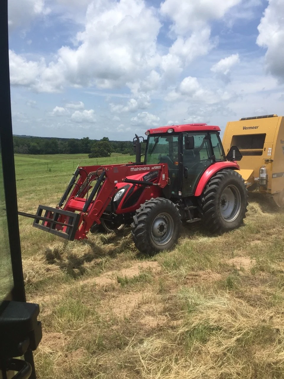 red tractor bailing hay