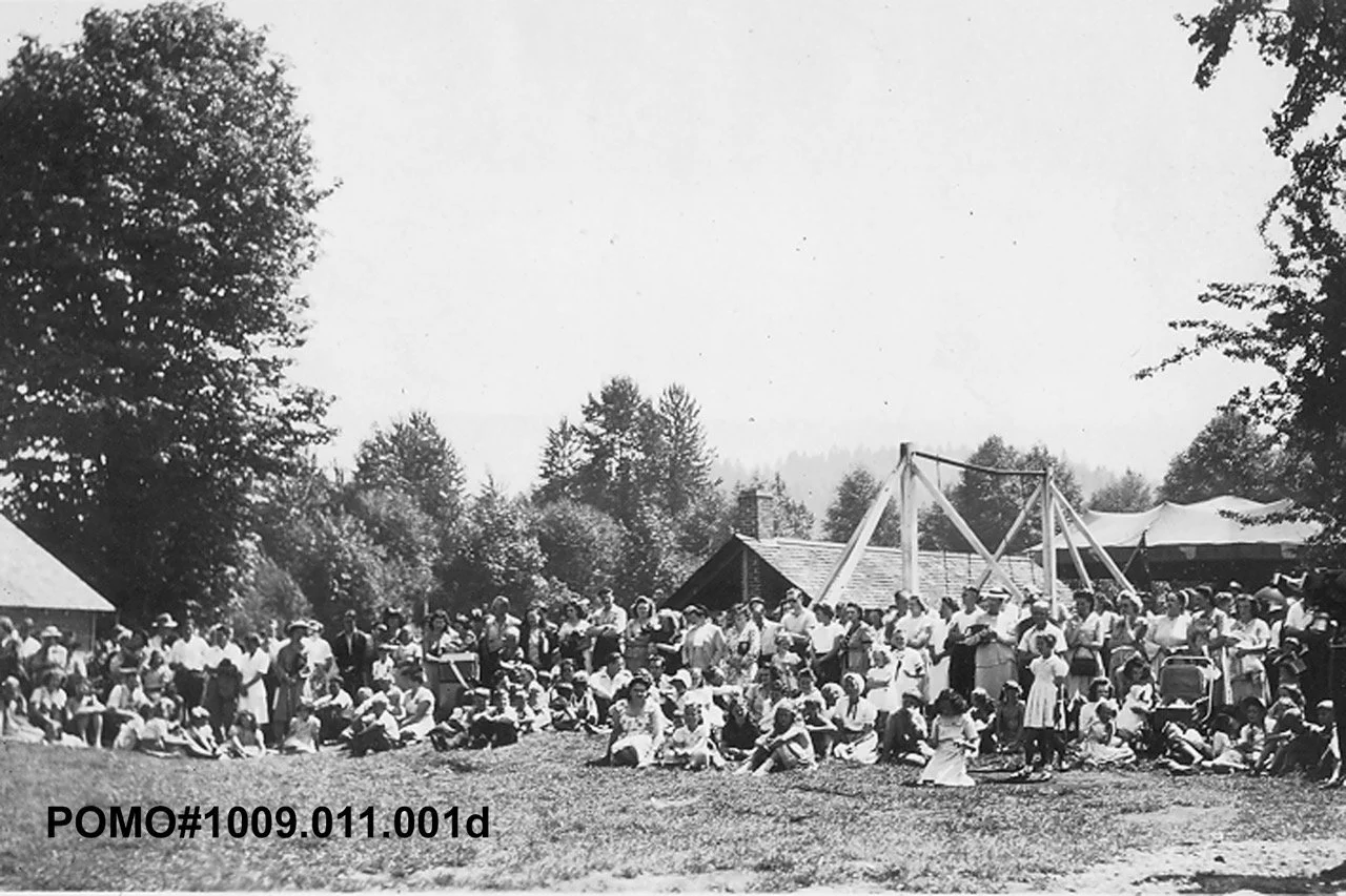 POMO# 1009.011.001d
Port Moody Carnival at Rocky Point, a crowd of people gathered on the grass. Date Unknown.