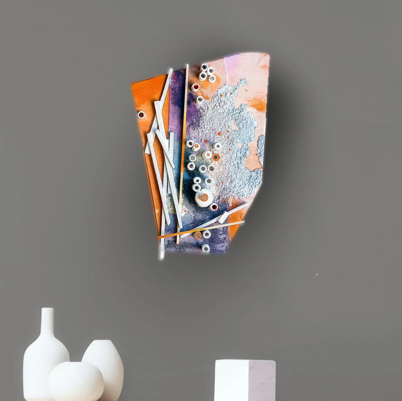 Abstract mixed media wall sculpture with wood pieces, painted in warm tones.