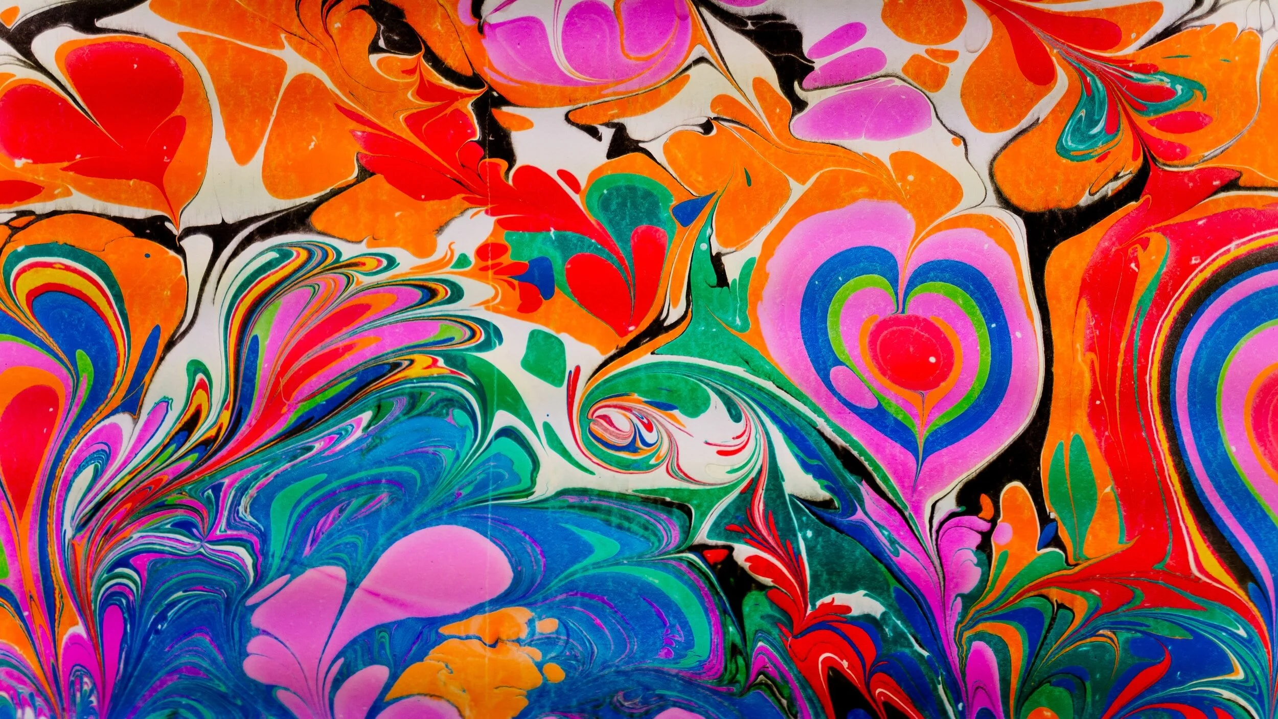 Bright, multicolored abstract swirled pattern with hearts and floral shapes.