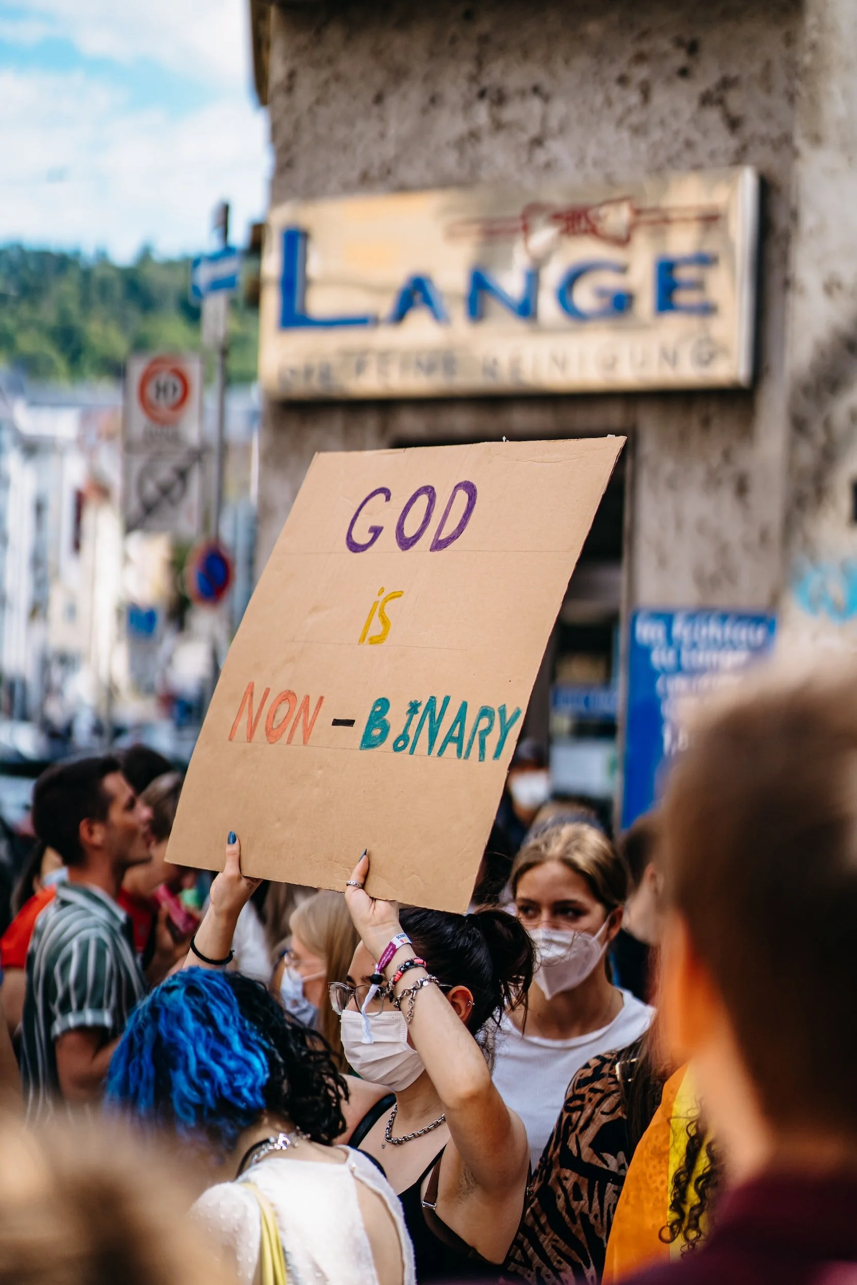 Woman holding a God is non-binary sign