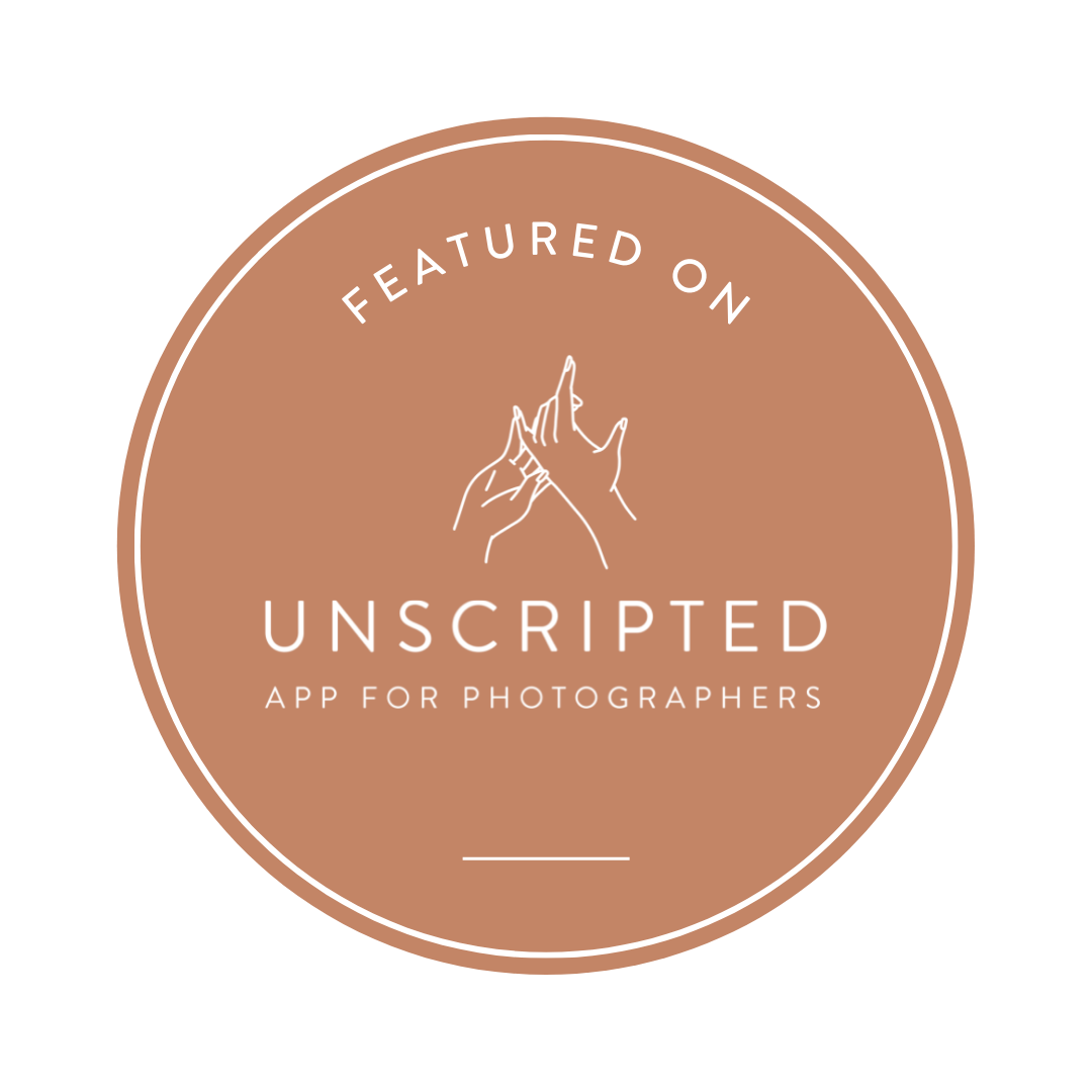 A circular badge with a brown background, featuring white text that reads "Featured on" at the top, an illustration of two hands snapping fingers in the center, "Unscripted" below the illustration, and "App for Photographers" at the bottom.