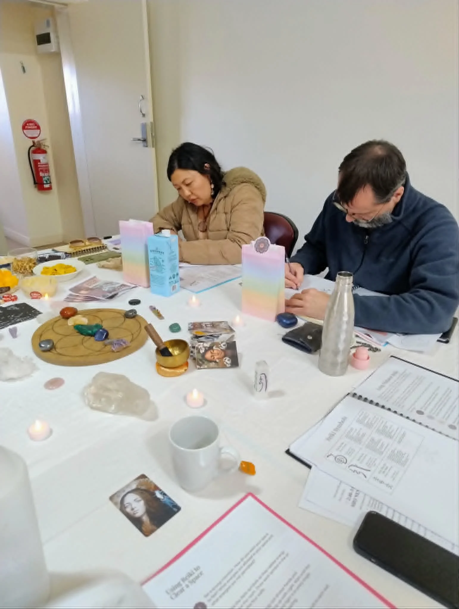 Students completing workbook at Reiki 2 Training with Aligned Soul Collective in Adelaide