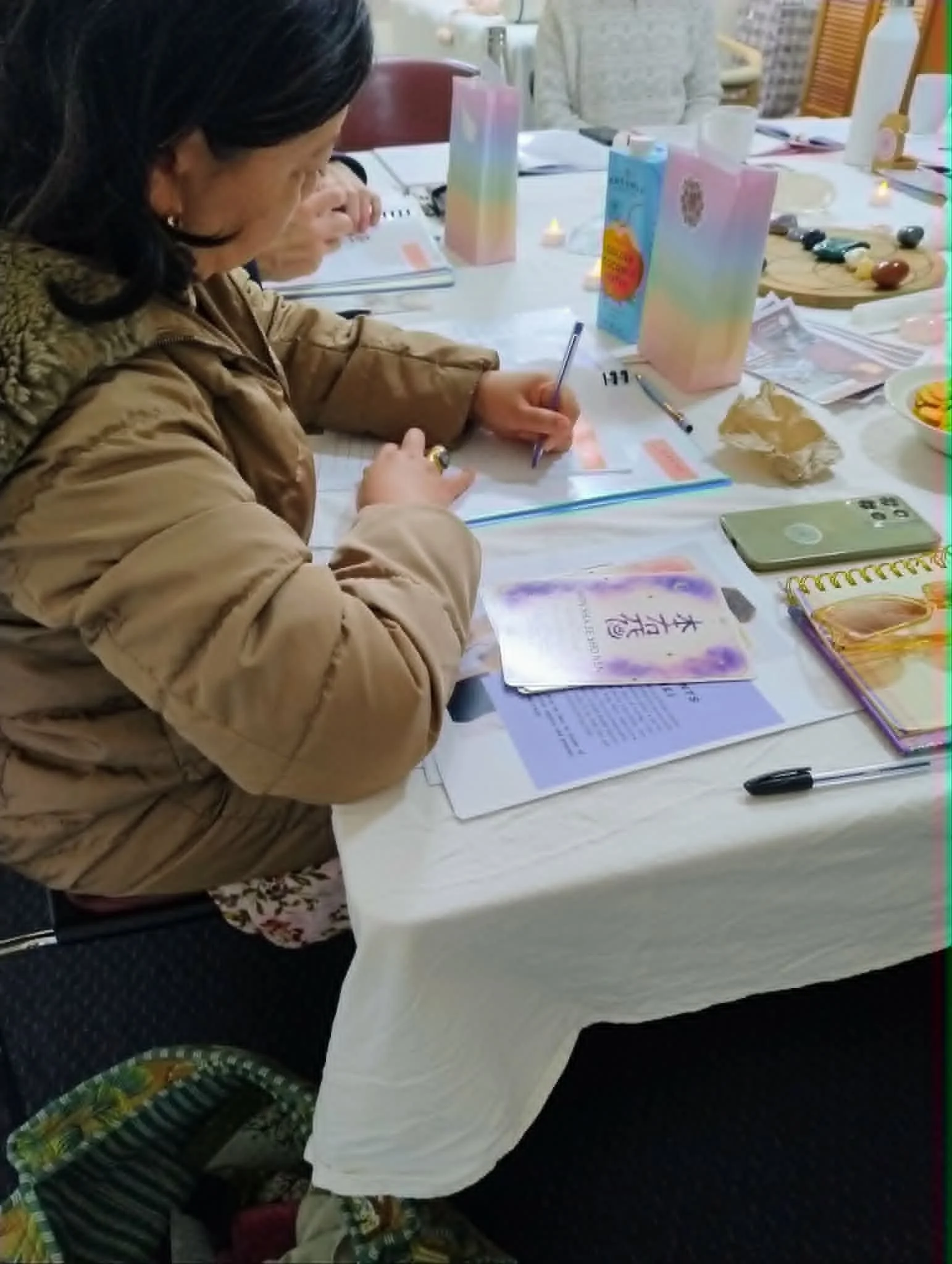 Student taking notes during Reiki 1 training Adelaide
