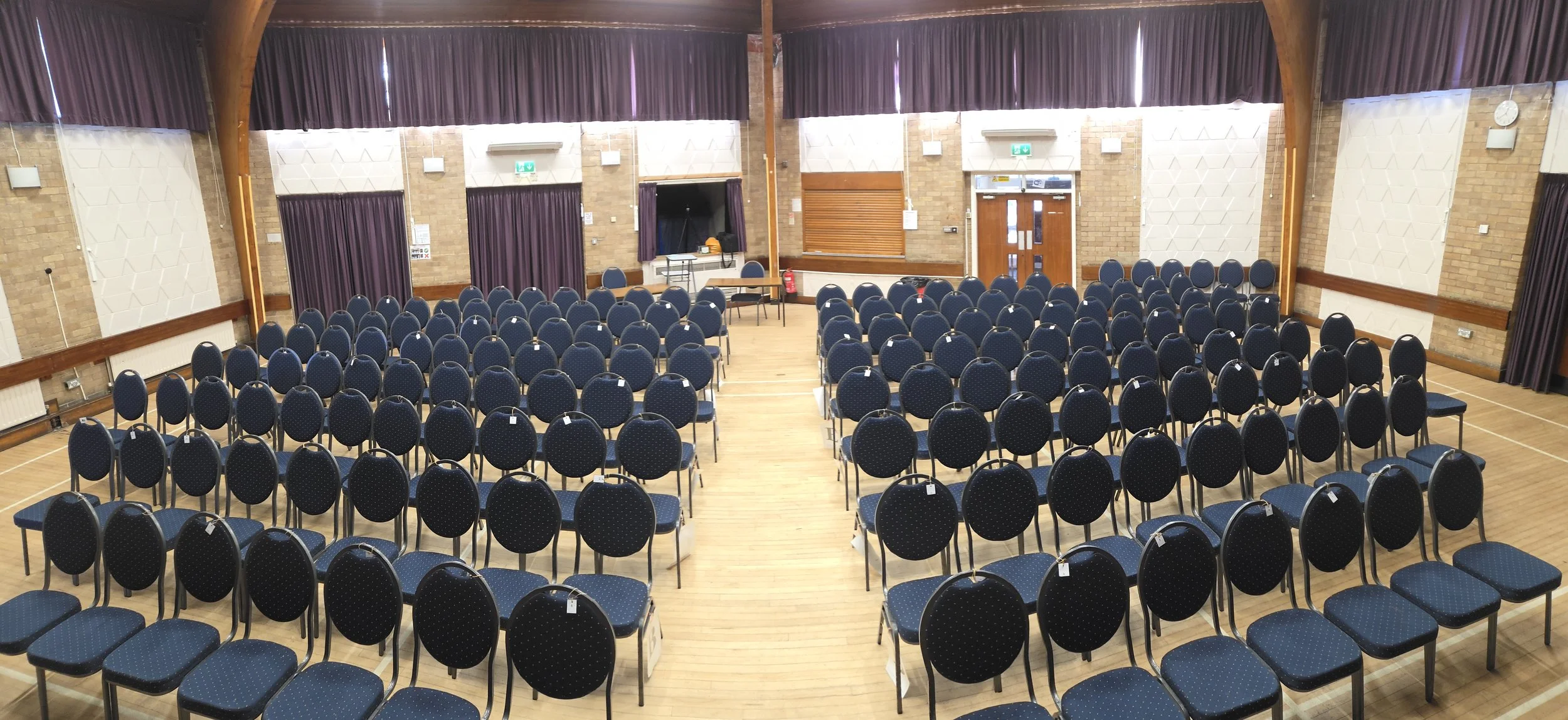 This is the main hall set out for a theatre production with 160 seats. Our maximum occupancy in this layout is 200. The wooden hatch at the rear is the kitchen servery. To the right of the photo the double doors lead to the Brammer Room.