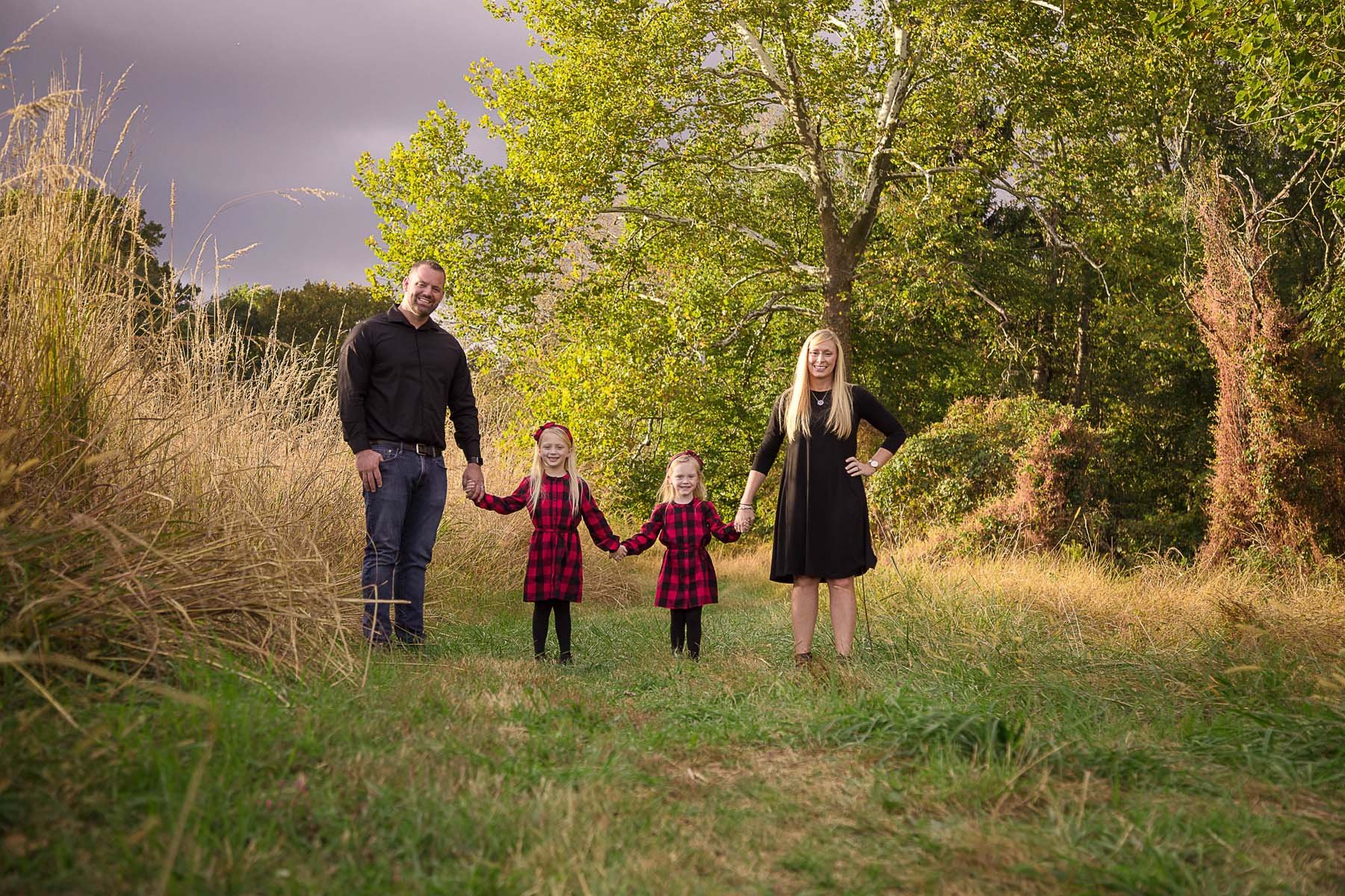 Family Posed in a Field for Family Portrait in Huntingdon Valley PA by photographer Wonderland Portrait