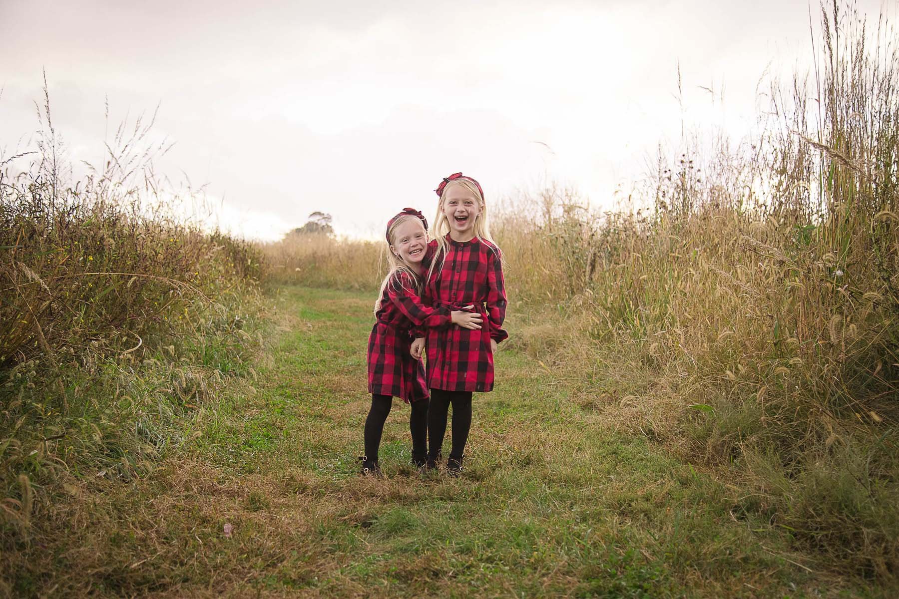 Sisters Posed in a Field for Family Portrait in Huntingdon Valley PA by photographer Wonderland Portrait