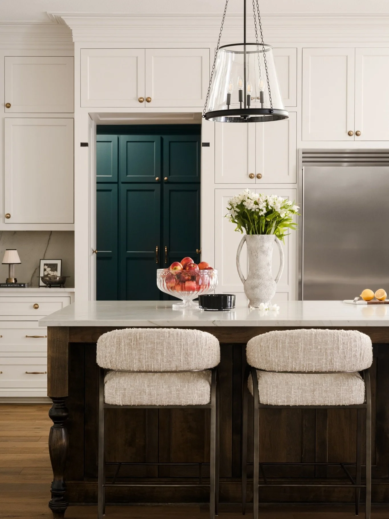 One thing I notice in beautifully designed kitchens is that your eye never really stops moving around.

From the warmth of the wood island to the painted cabinetry, the contrast of black steel and aged brass, and finally the deep blue mudroom beyond,