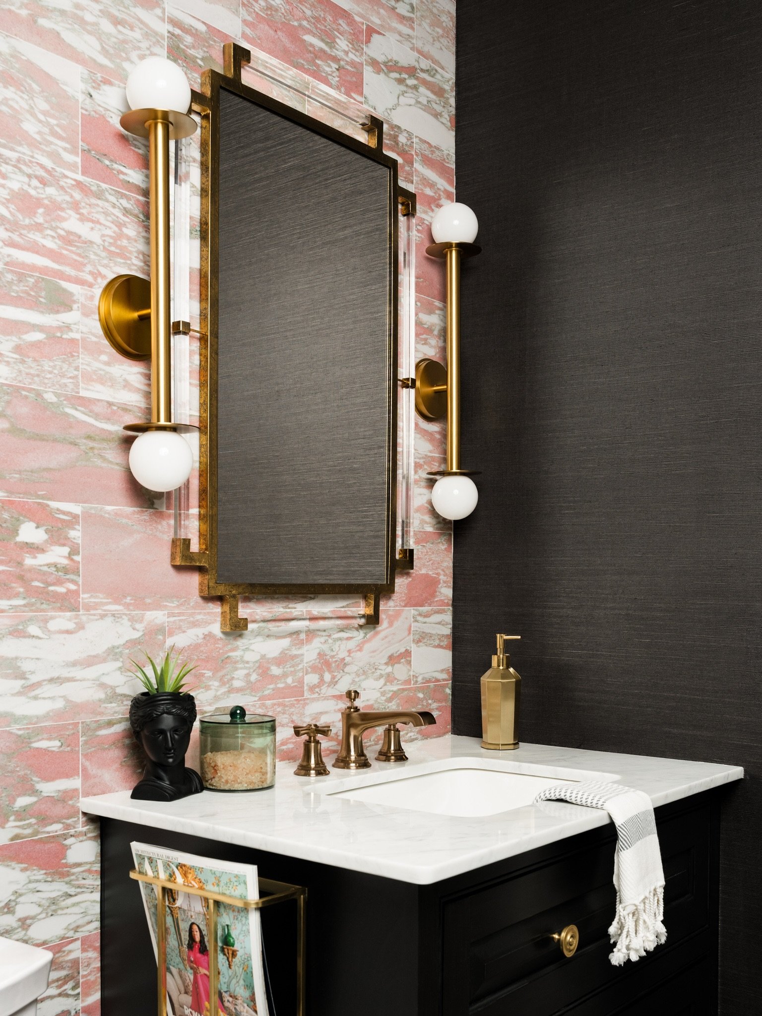 In the upstairs guest bathroom of @katethackerhome&rsquo;s Modern Parisian Craftsman project in Dallas, pink marble tile meets a black vanity, brass sconces, geometric flooring and a dramatic stone-slab shower.

Every material is allowed to be bold a