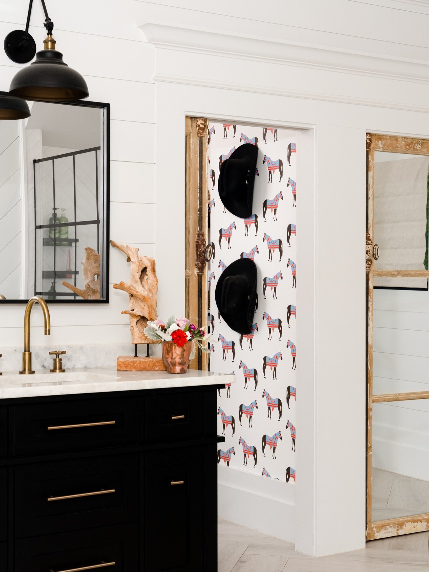 Primary Bathroom Reveal | Cross Roads, Texas

@britneyratto gave this modern farmhouse primary bath black cabinetry, warm brass, weathered wood, white shiplap, a chandelier over the bathtub, and then casually tucked colorful horse wallpaper around th
