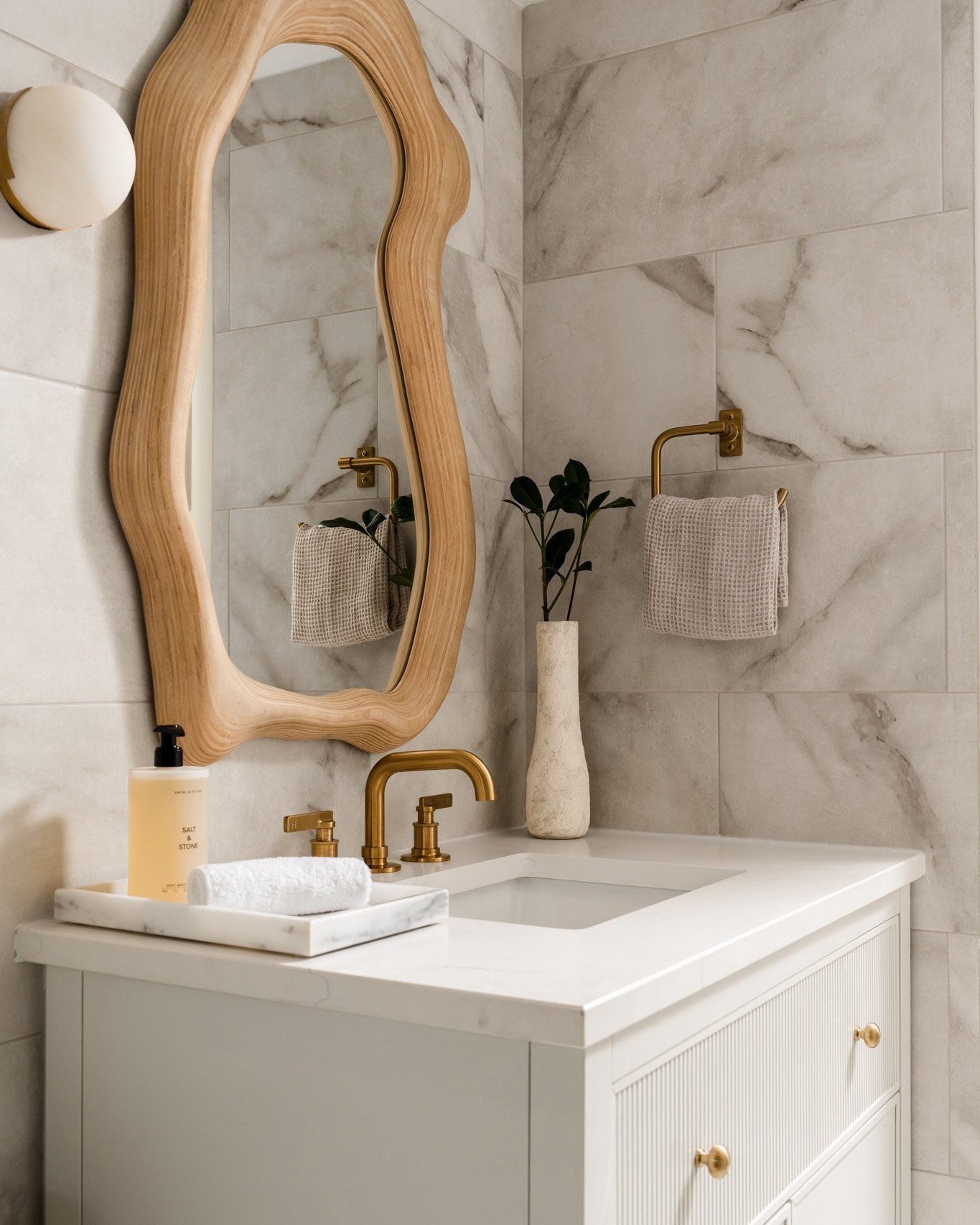 I would like to formally request more squiggly mirrors on walls, especially In bathrooms.

That sculptural wood frame against all that tile? Yes. Warm brass, fluted cabinetry, a little greenery? Also yes.

Nikki Chu always hits.

Design: @nikkichuhom