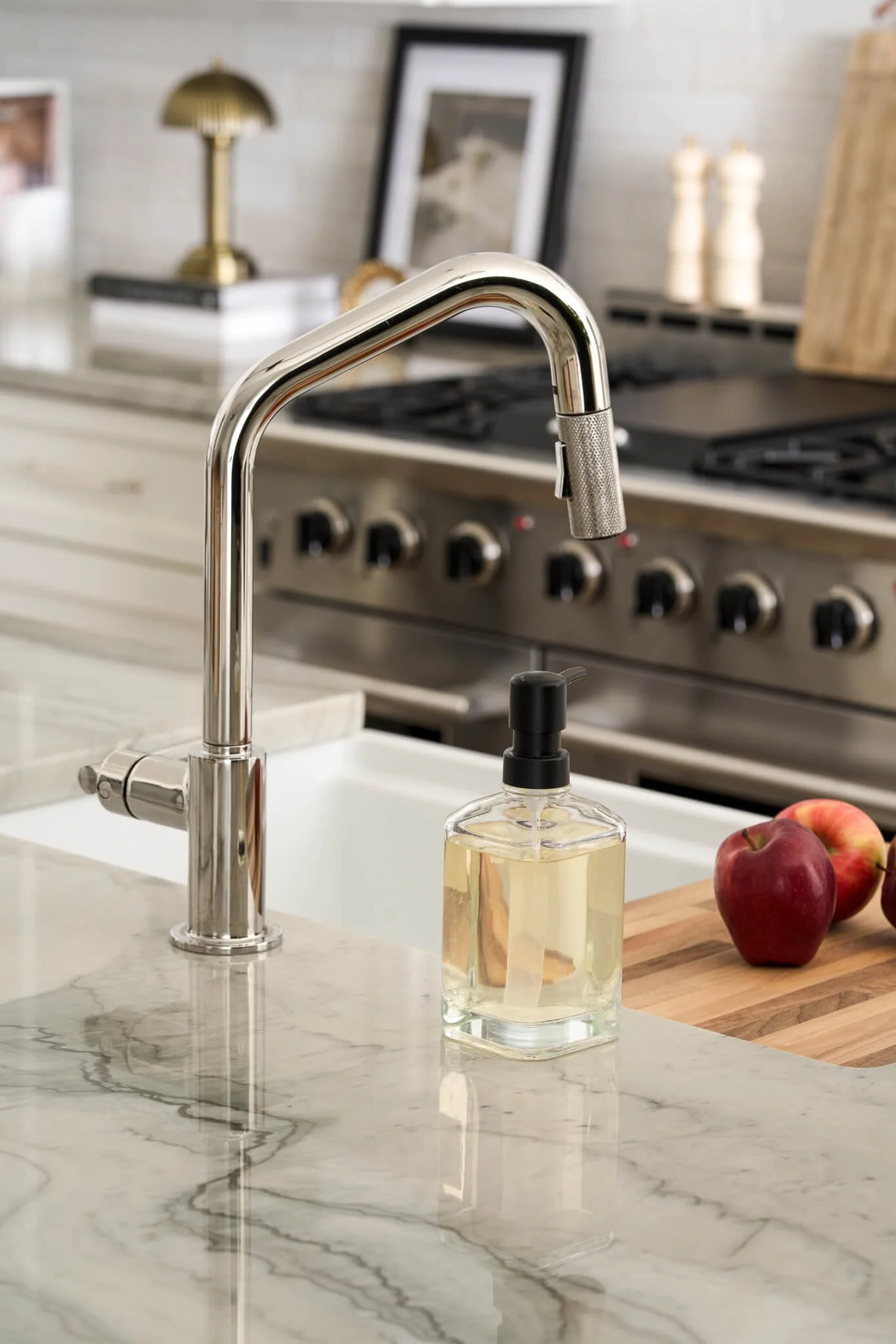 Detail shot of a polished chrome sink on a natural stone veined countertop. Stacy Markow Texas Interior Photographer