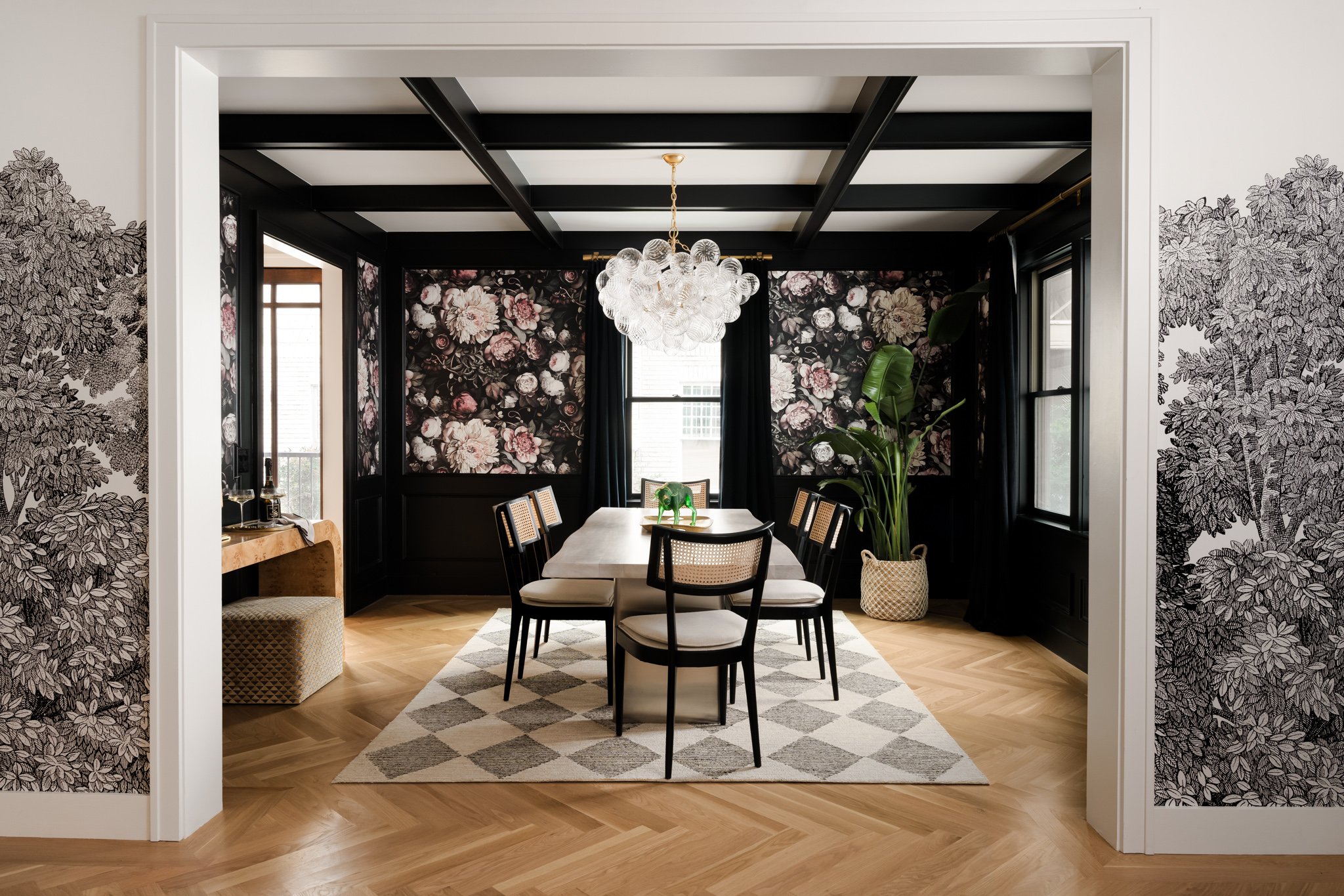 Moody luxury dining room with floral wallpaper, crystal chandelier, and dark paneled walls photographed by Dallas interior design photographer Stacy Markow.