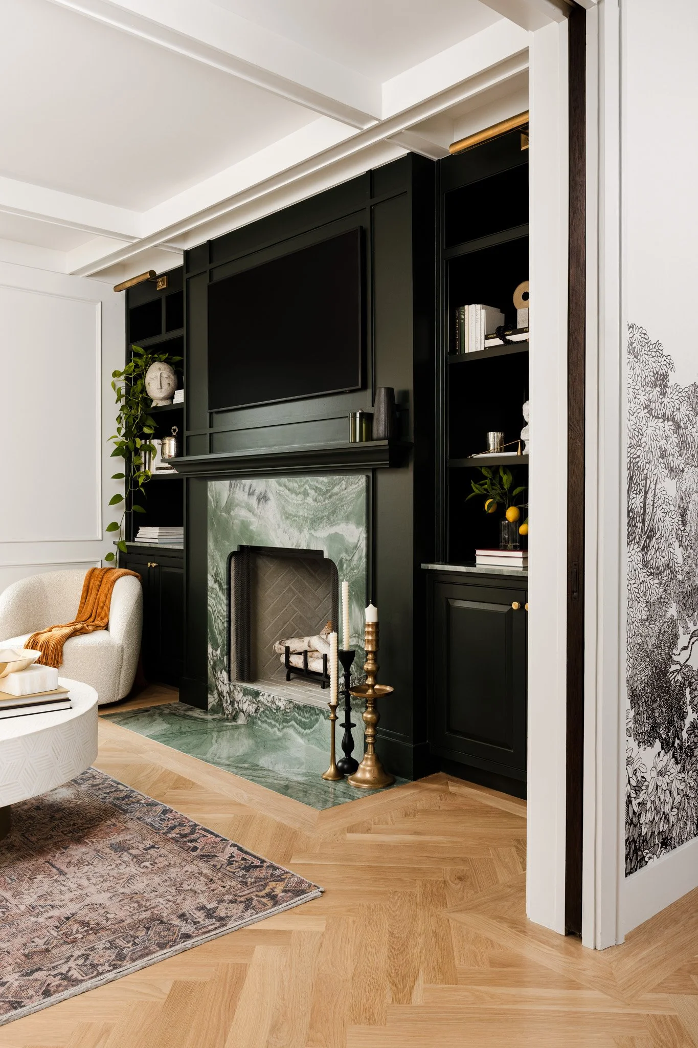 Moody white and green living room with marble fireplace and built-in cabinetry. Design by Kate Thacker Home